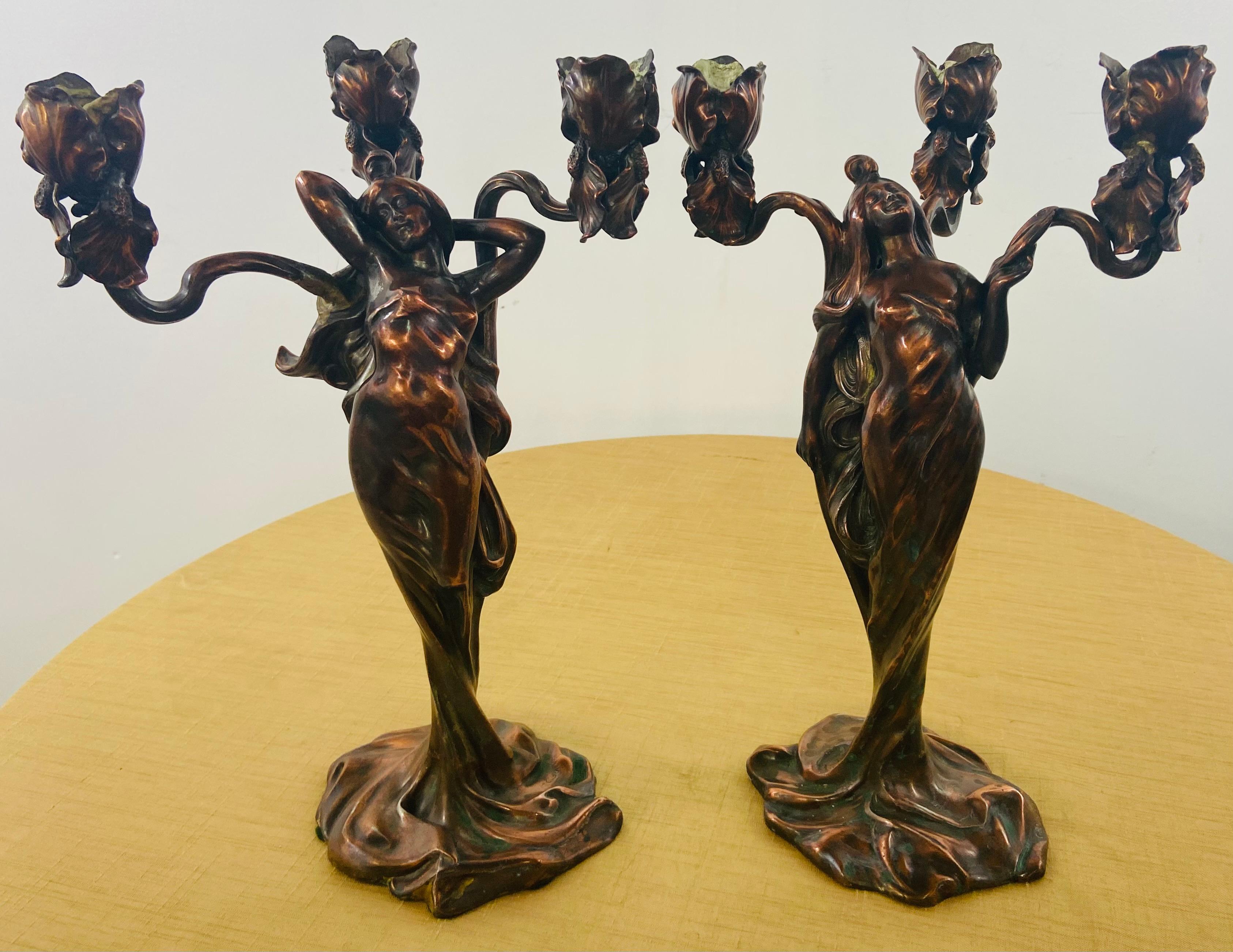 An early 20th century spectacular pair of bronze plated figure of a sinewy and nature loving maiden holding three arm candelabras with flower design by Claude Bonnefond (or Jean - called Bonnefond 1796-1860 a French painter, lithographer and