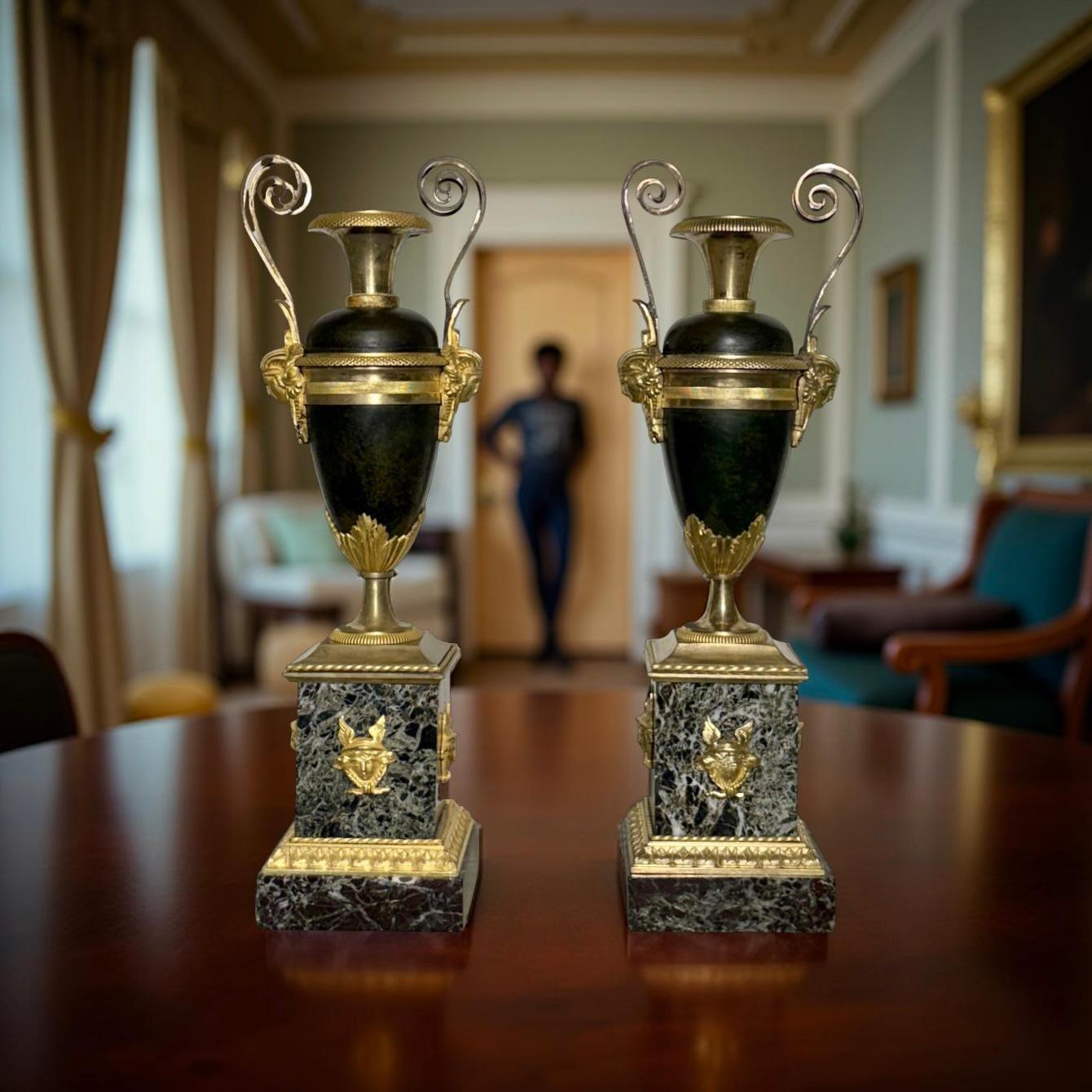Paire d'urnes en bronze et marbre d'époque Directoire attribuées à Claude Galle (1759-1815).  
Les deux urnes ovoïdes sont coulées dans une alternance de bronze patiné et de bronze doré au mercure, avec des poignées finement ciselées ressemblant à