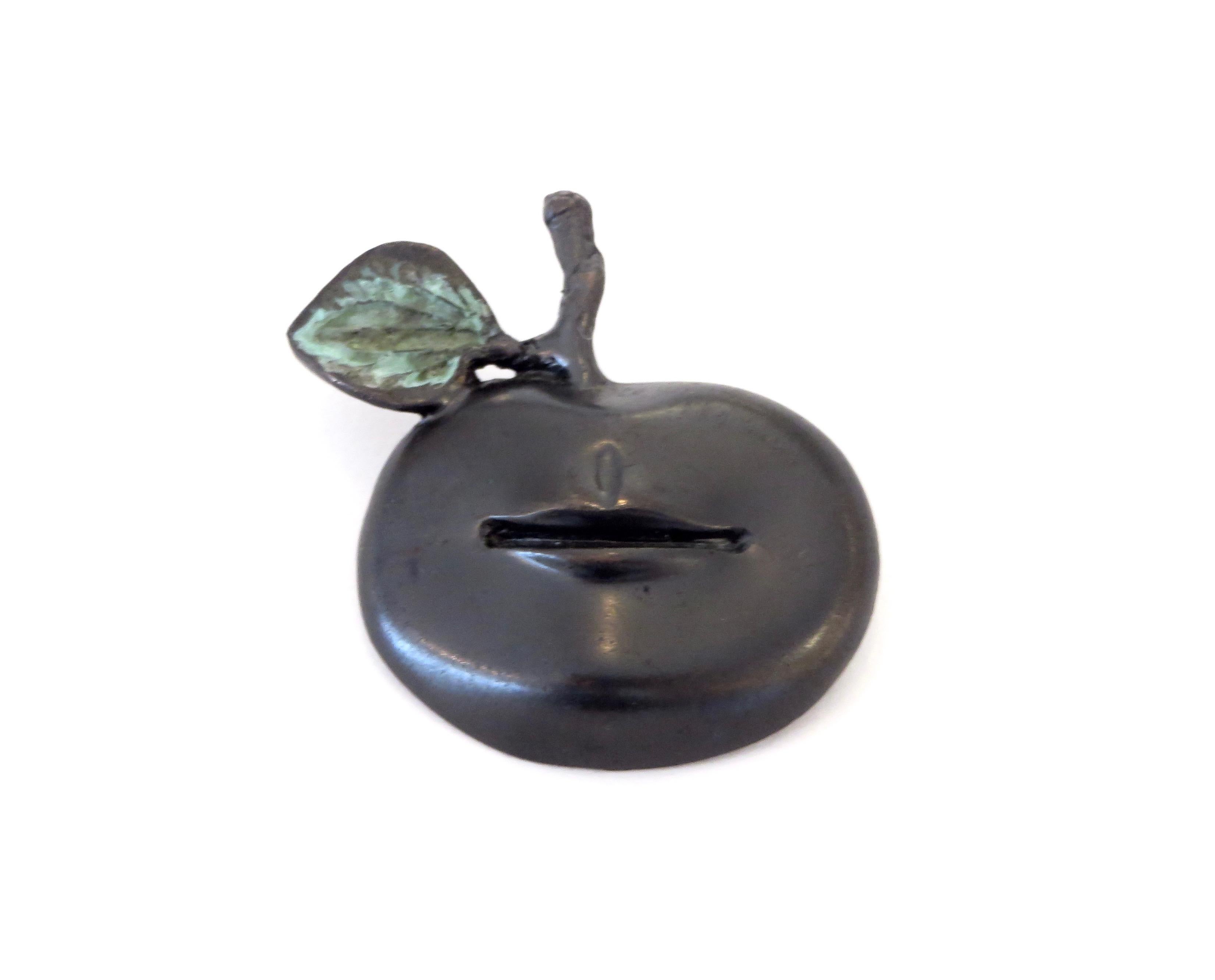 Surrealistic Pomme Bouche brooch by Claude Lalanne, created in 1975. Bronze with a dark brown patina and a verdigris leaf and stem, signed with editions mark and monogrammed Arthus-Bertrand. In 1996 the pin was reproduced by Arthus Bertrand on the