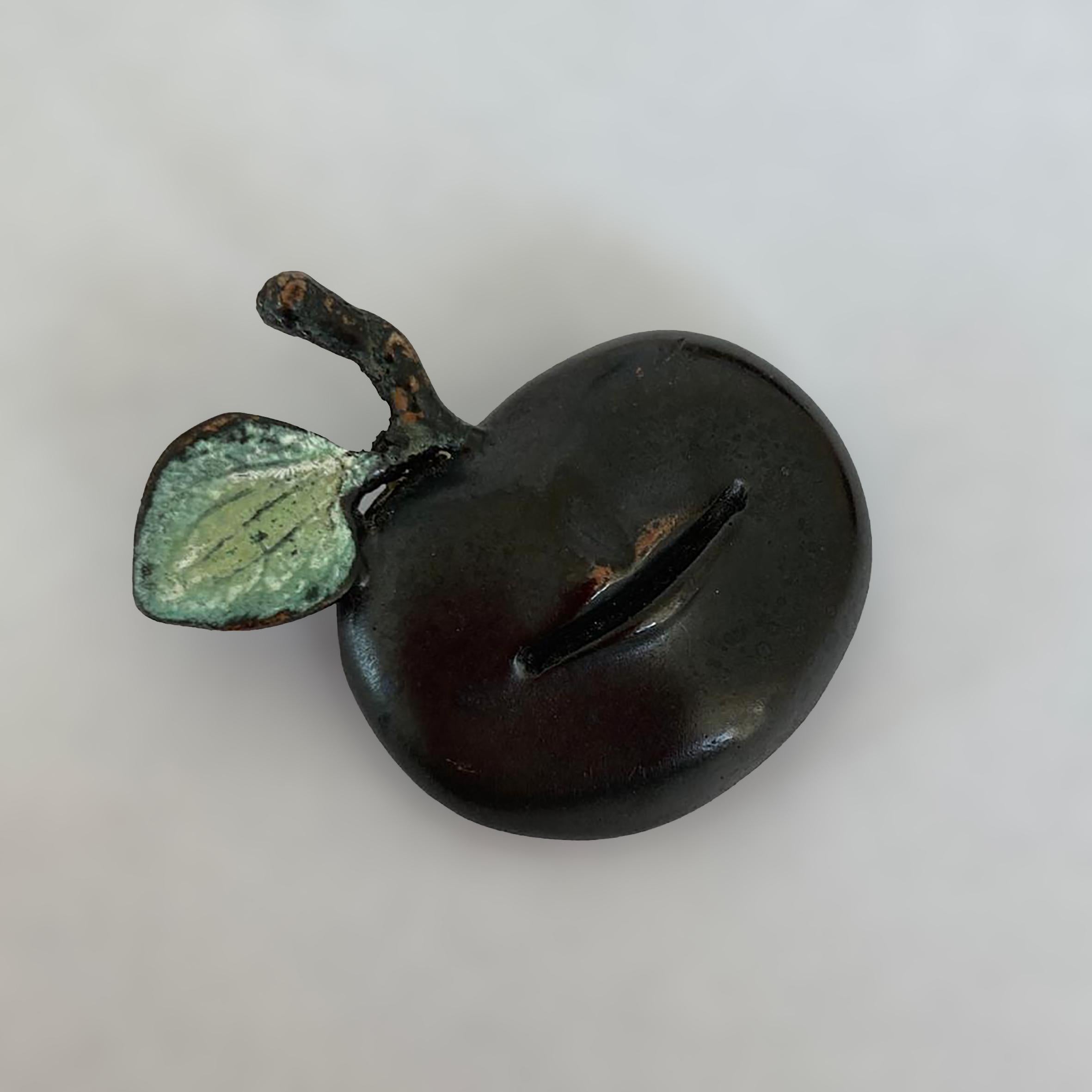 Claude Lalanne (1924-2019)

Pomme Bouche

A patinated bronze brooch figuring an apple with a human mouth surmounted with a green patinated leaf next to the apple tail.
Monogrammed « C.L. » and « Lalanne » on the back. With maker’s mark «  A-B