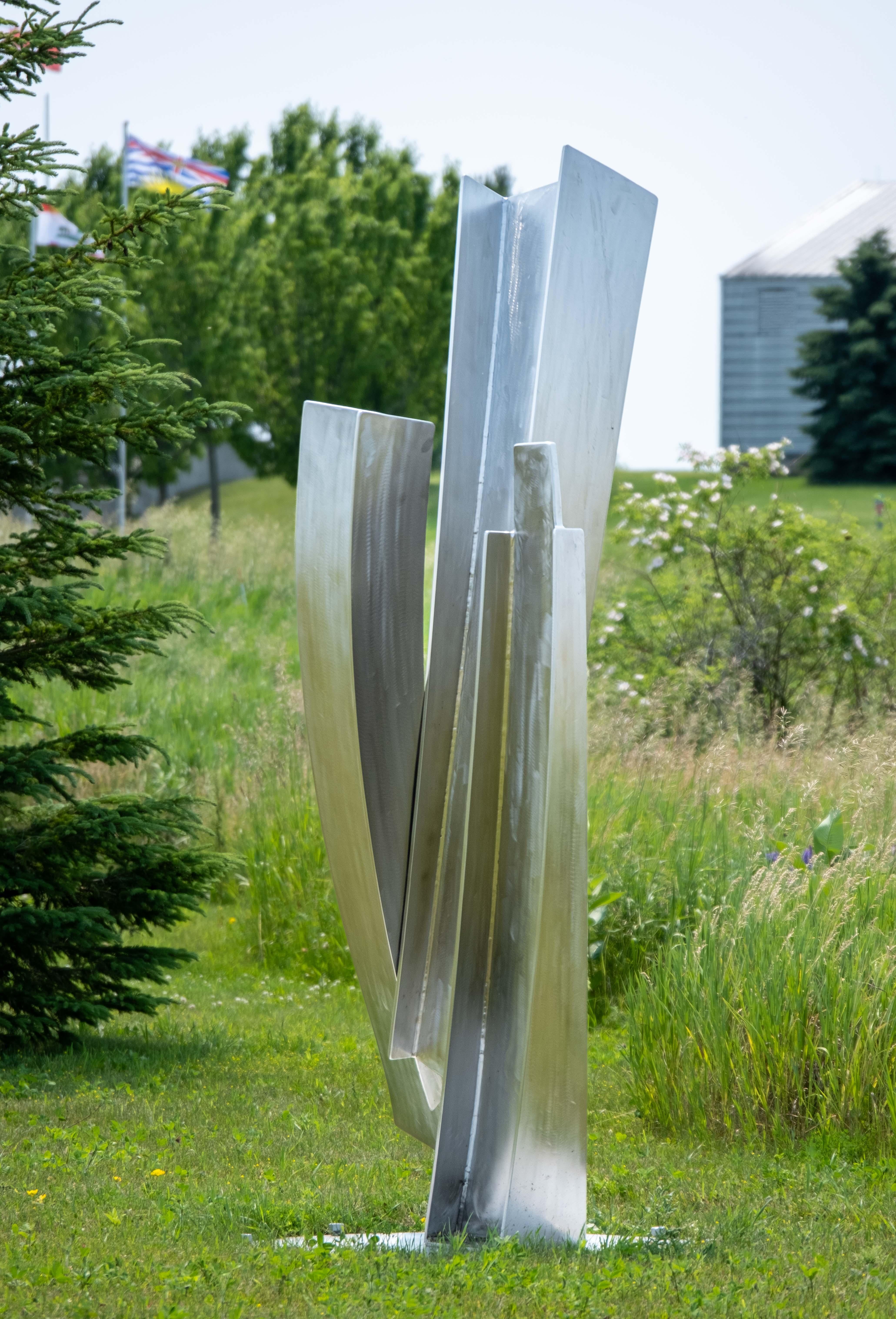 The graceful arc of a dancer in motion is emulated in the fluid form of this elegant sculpture by Claude Millette. Three attached curved columns of polished stainless steel appear to almost float in mid-air. The Quebec artist whose career spans four