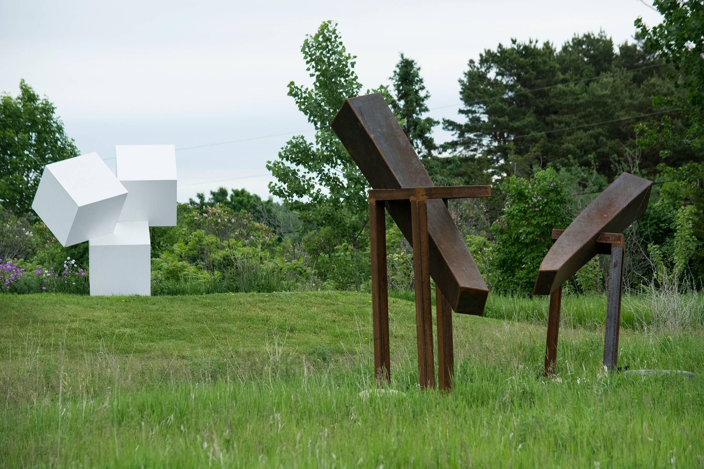 In this dynamic sculpture by artist Claude Millette corten steel is shaped into a right-angled curve and sits on a narrow stand. Corten steel, in time, will naturally rust but maintains its integrity. 

Millette’s work is always non-figurative and