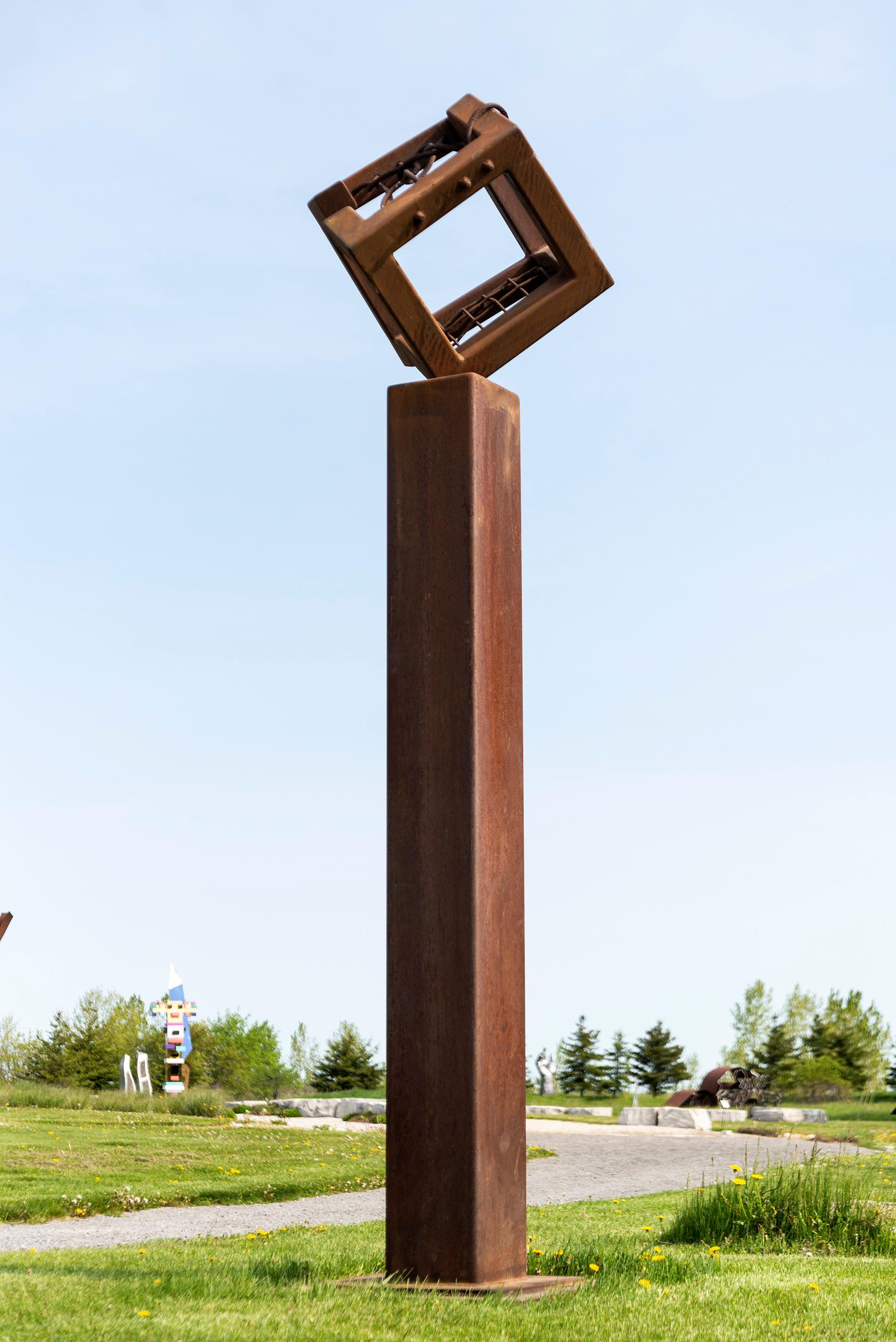 Quebec artist Claude Millette has been creating uniquely compelling sculptures for more than four decades. This outdoor piece in corten steel features a cube-like open frame (‘broken’ on one side, netted on another) that balances on one corner on