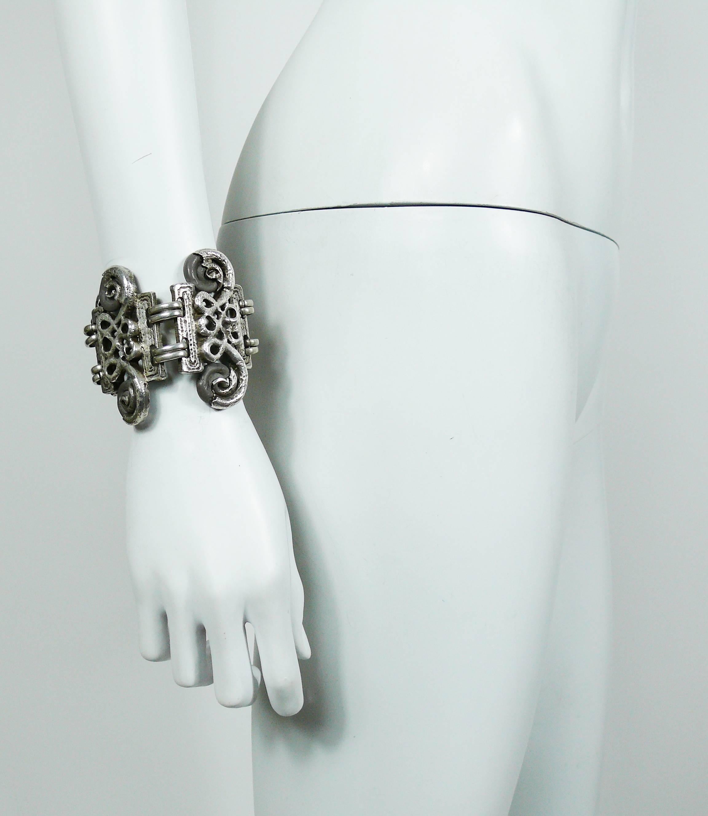 CLAUDE MONTANA vintage antiqued silver tone cuff bracelet featuring arabesque design links embellished with grey resin cabochons.

Created by french jewelry designer CLAIRE DEVE.

Marked CLAUDE MONTANA pour CLAIRE DEVE.

Indicative measurements :