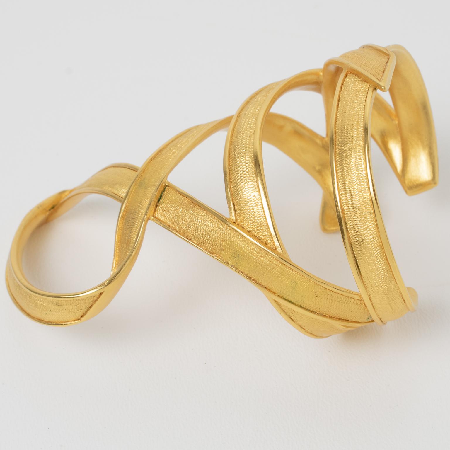 Claude Montana designed this stunning cuff bracelet for Marie Paris. The rare piece has a massive, Hellenistic-inspired, intricately carved, see-through shape with textured gilt metal and lace. The engraving on the inside reads 