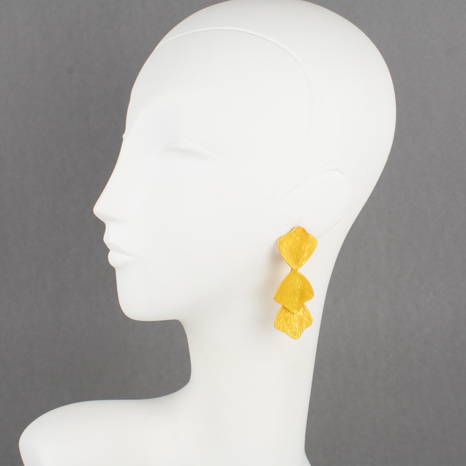 Claude Montana designed these romantic clip-on earrings for Marie Paris in the 1980s. They feature a floral dangling drop shape with gilded metal, all textured and carved in water lily leaves. Both pieces are marked on the underside with the