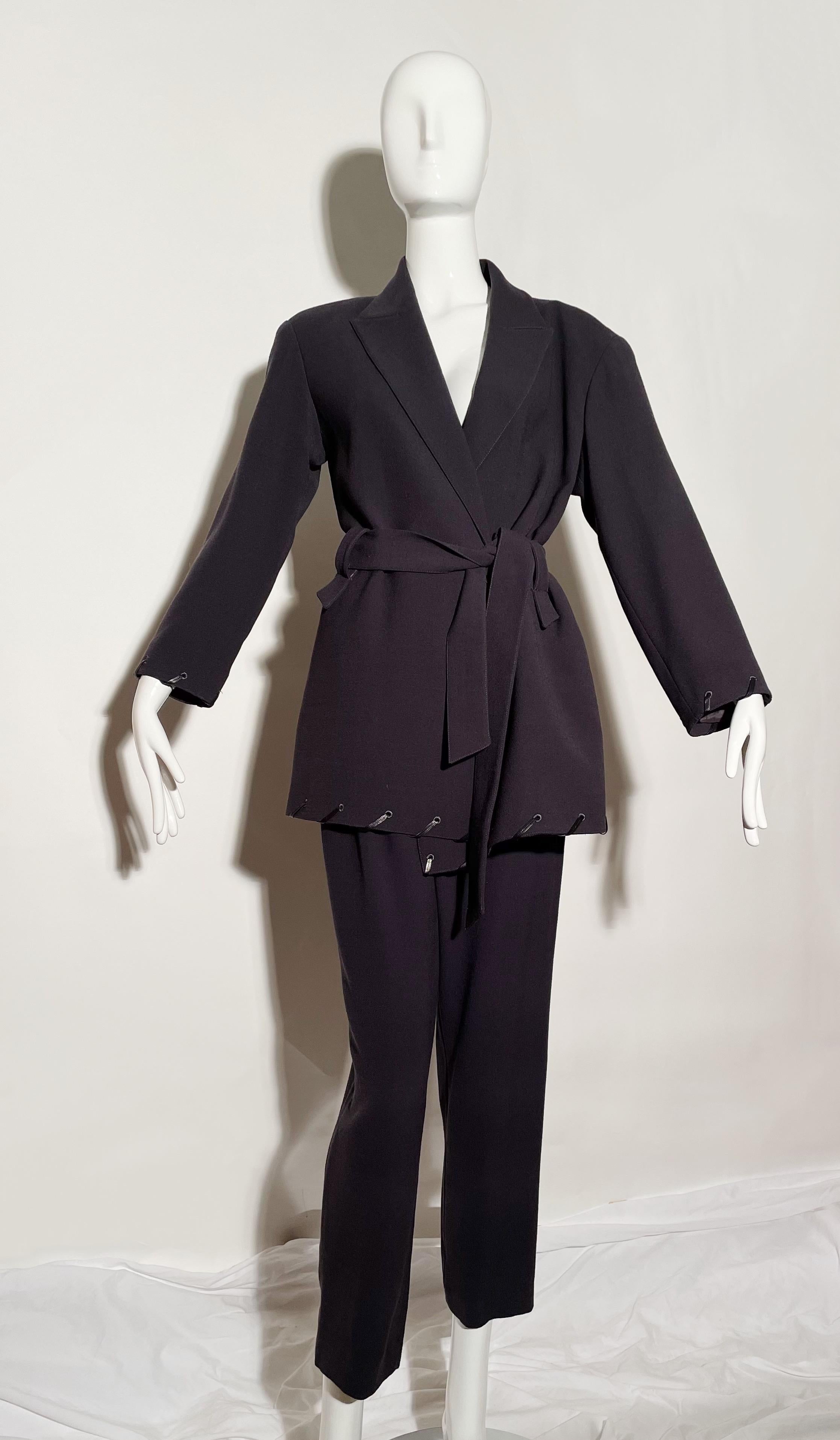 Charcoal grey pant suit. Woven leather trim. Belted. Shoulder pads. Side zipper on pants. Lined. Made in Italy. 
*Condition: Excellent vintage condition. No visible Flaws.

Measurements Taken Laying Flat (inches)—
Shoulder to Shoulder: 17.5