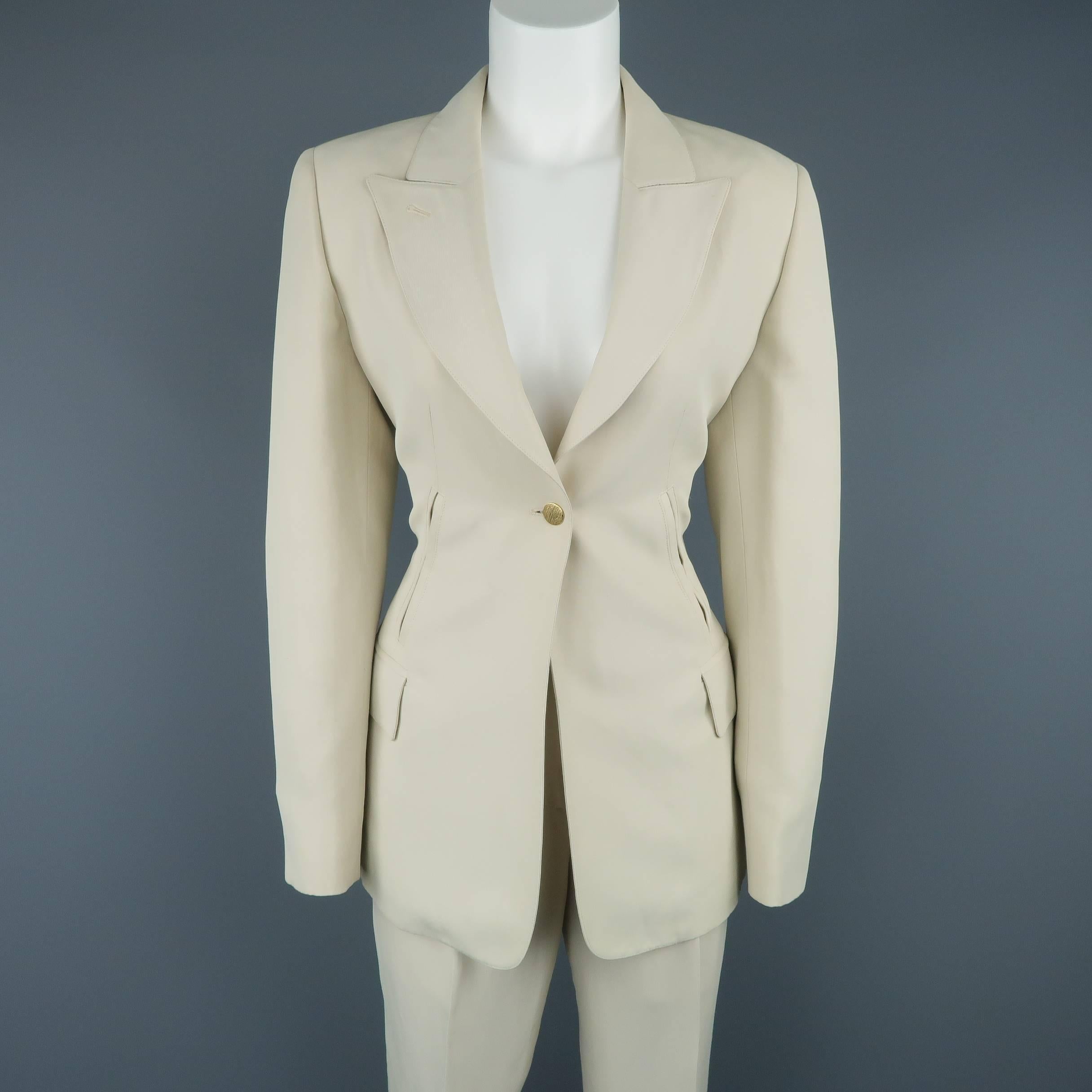 Vintage CLAUDE MONTANA pants suit comes in a light khaki beige twill with a sheen and includes a single button, peak lapel jacket with slit and flap pockets and matching trousers. Minor wear and spot on back of sleeve. As-is. Made in Italy.
 
Fair