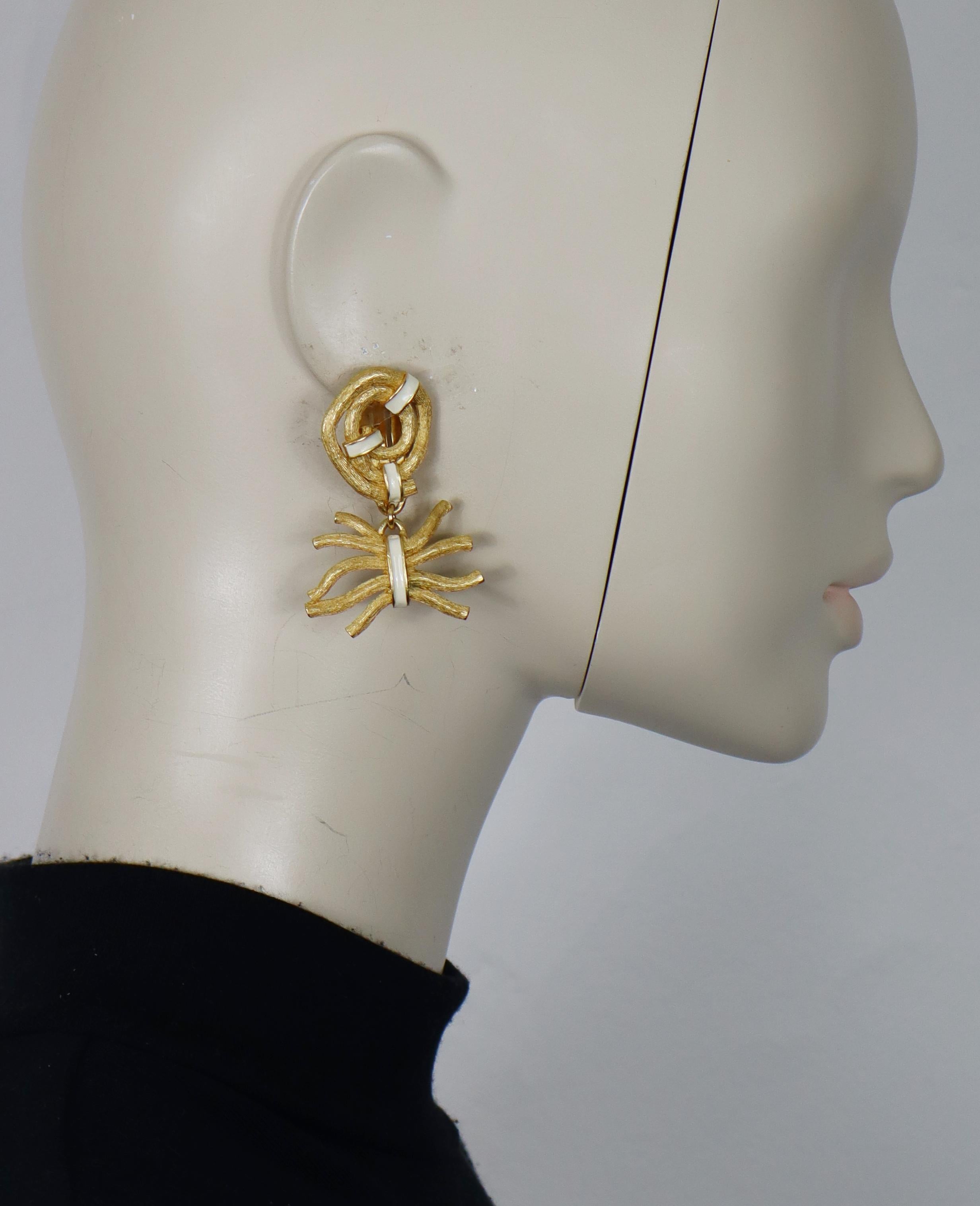 CLAUDE MONTANA vintage ribbed gold tone and white enamel dangle earrings (clip-on).

Embossed MARIE PARIS pour MONTANA.

Indicative measurements : max. height approx. 4.5 cm (1.77 inches) / max. width approx. 3.5 cm (1.38 inches).

Weight per