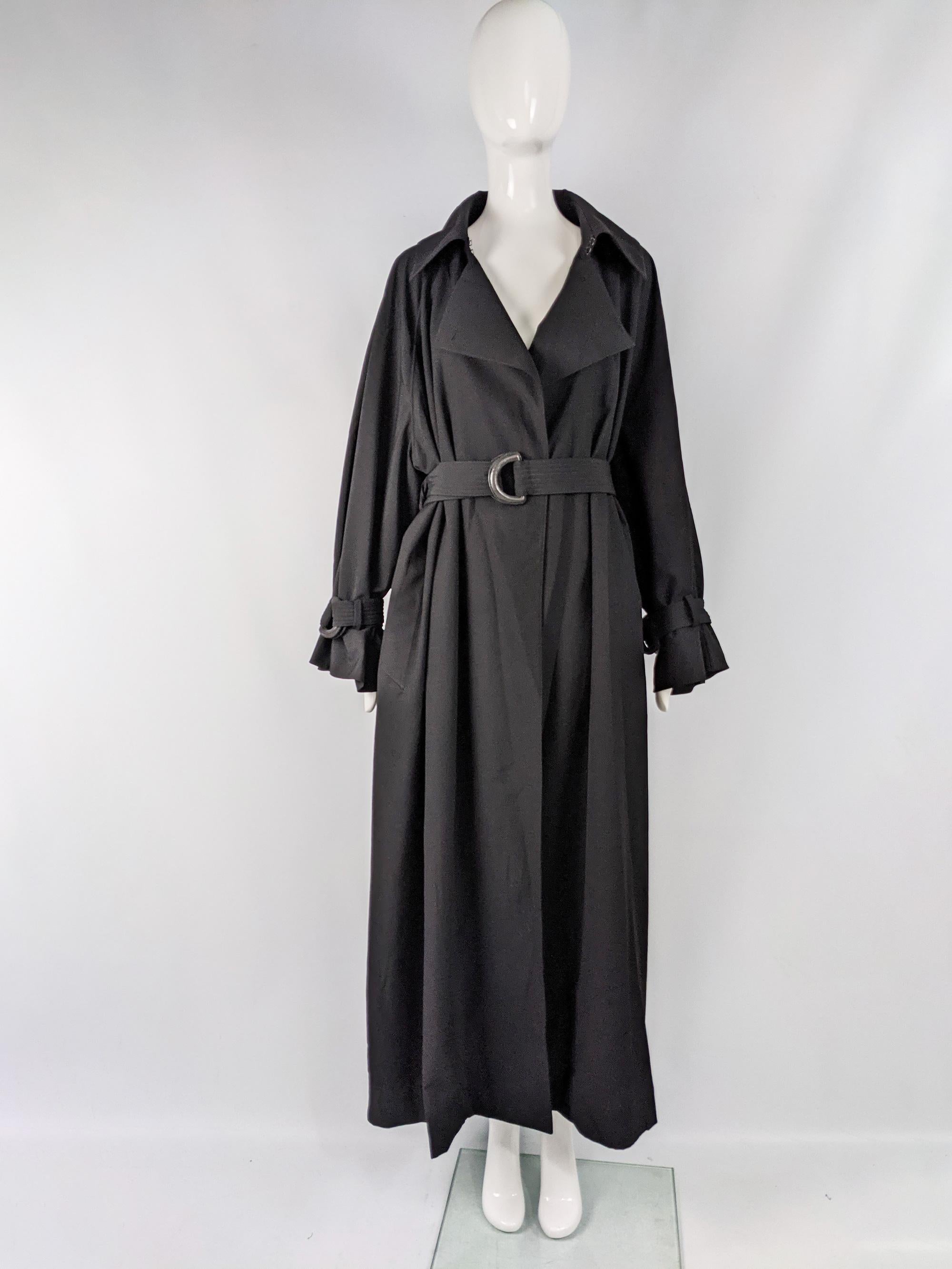 A stunning vintage womens Claude Montana mainline maxi trenchcoat from the 80s. In a light black wool trench coat fabric with a dramatic, full length and an oversized fit that gathers and looks incredible when pulled in with the belt. 

Size: Marked