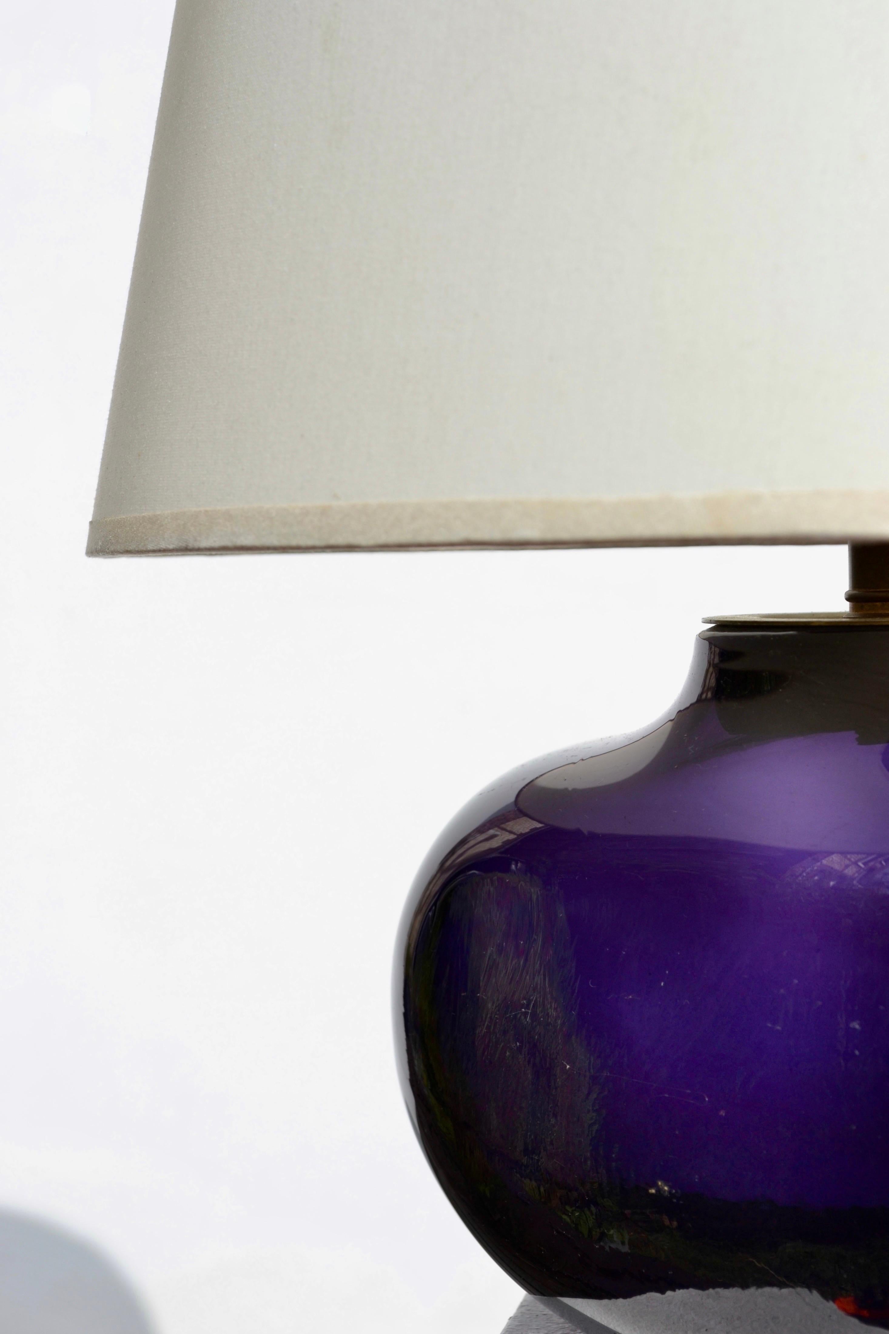 An exceptional and rare table lamp by renowned French glass artist Claude Morin, created circa 1970. The sculptural base, hand-blown in a sumptuous deep violet glass with luminous depth and subtle variations, reflects Morin’s mastery of organic form