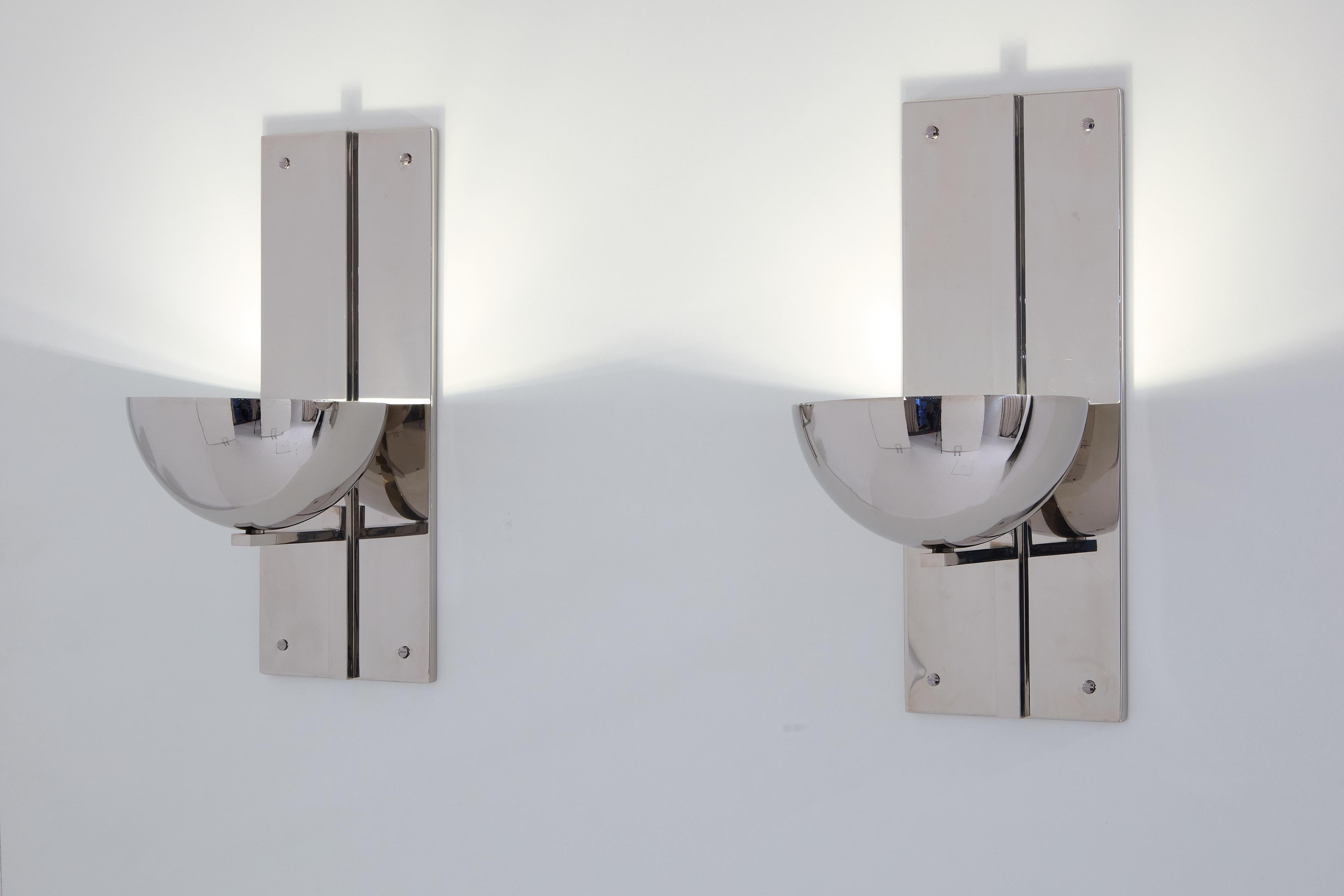 This is a unique pair of French wall lights designed by the famous architect Claude Parent in 1992 for a mansion project in the 16th arrondissement of Paris. The structure is made of polished nickel steel, with a large globe with a nickel finish on