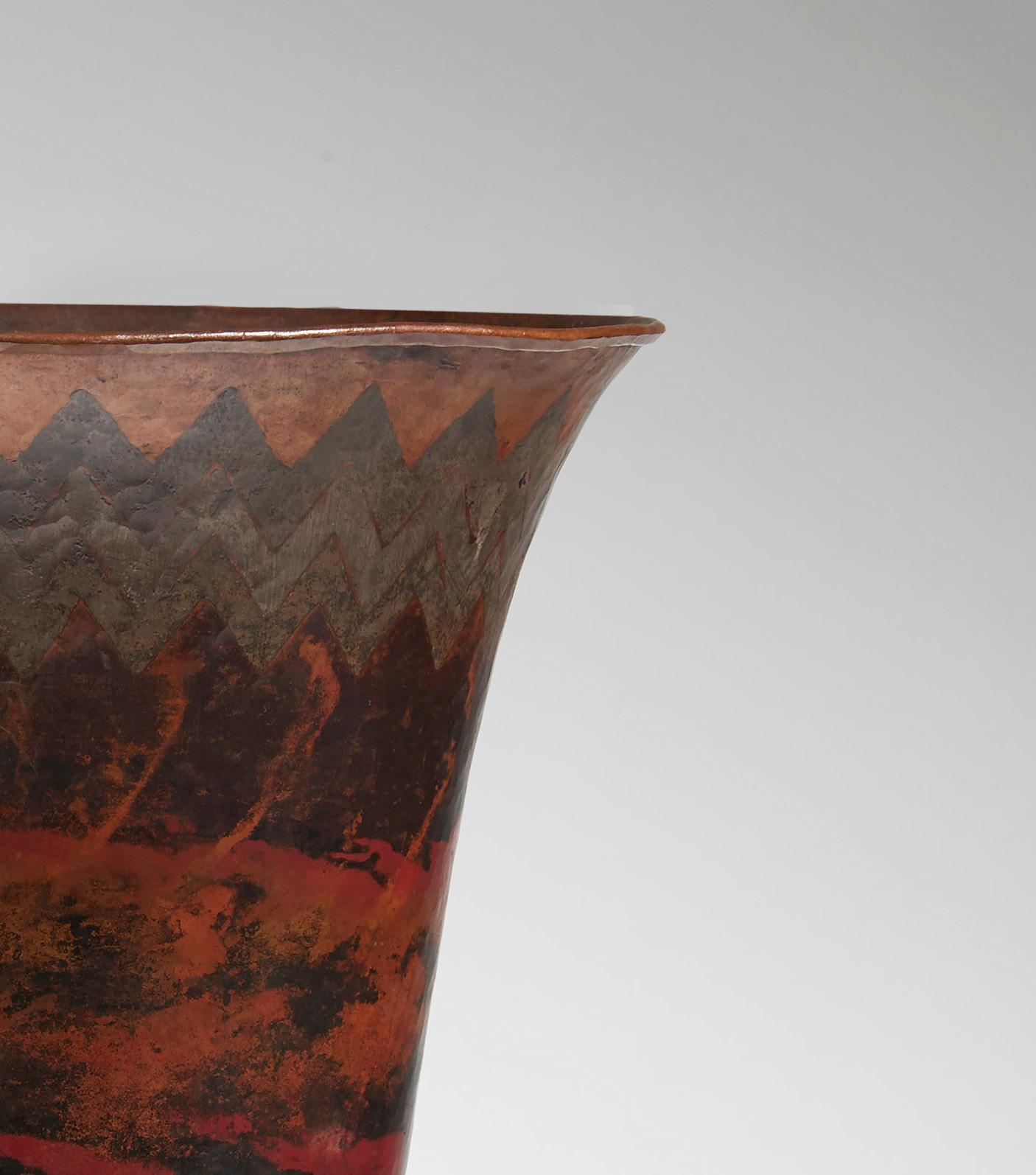 Cornet shaped vase on a truncated cone shape foot in copperware, with a zigzag frieze on the collar and red, orange, grey and black marblings on the belly
Signed 