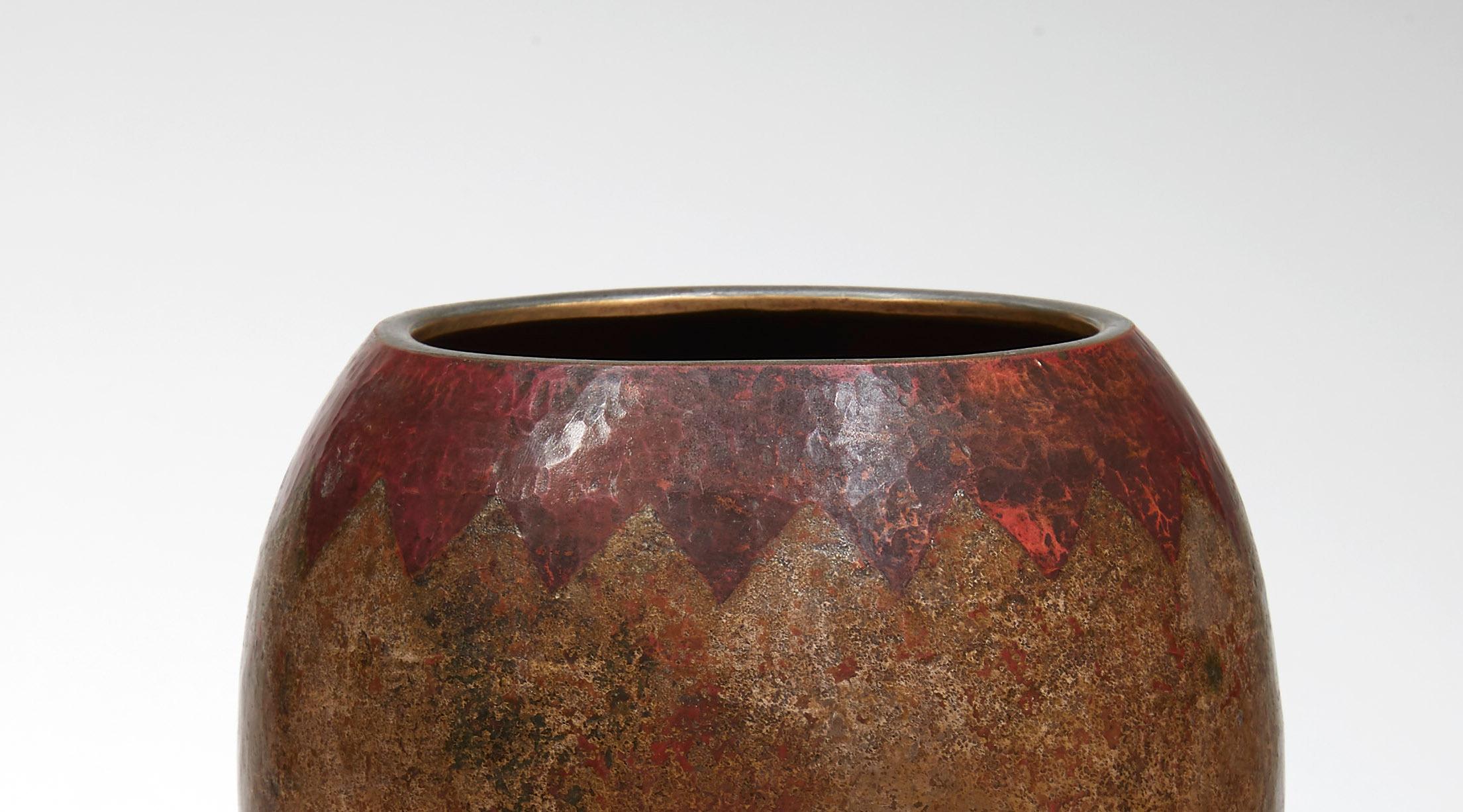 Egg-shaped vase with in copperware with a moiré patina and herringbone frieze decor on a red background. Signed and dated 1943 under the base.