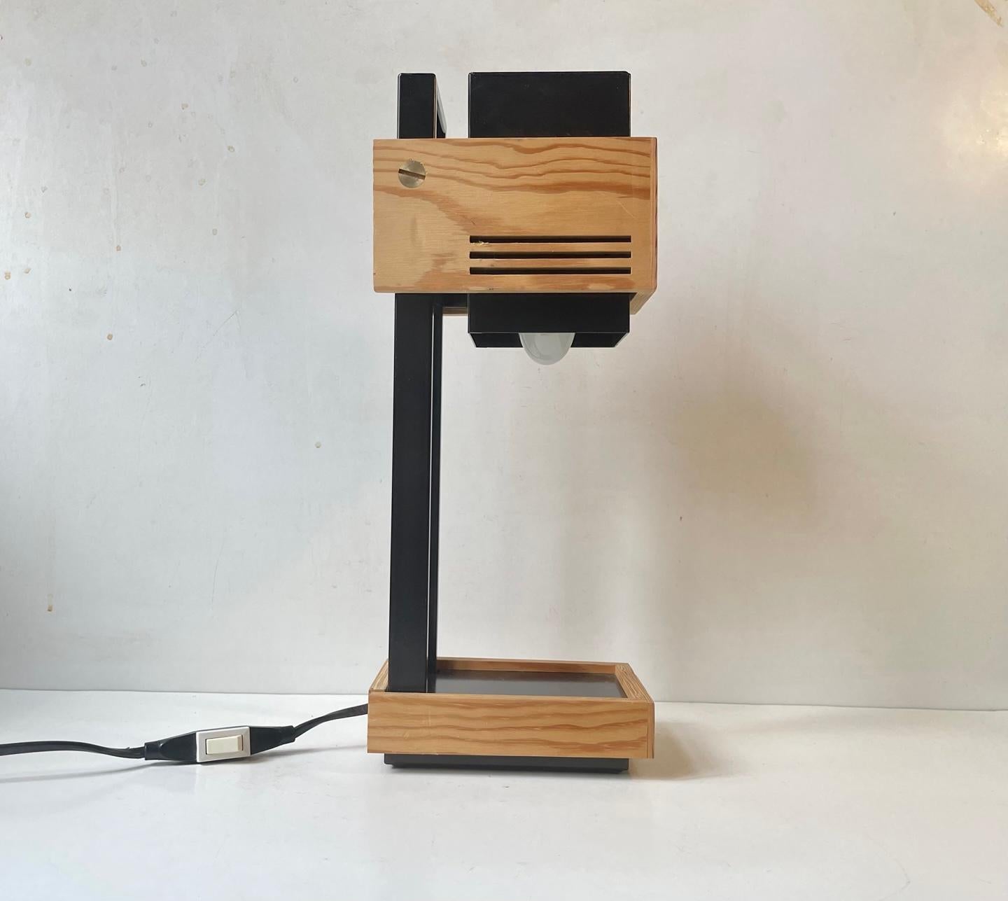 A very rare table light in Black lacquered steel and plywood. Within the realm of constructivist/cubist designs. Design number 9002 designed by Claus Bolby and manufactured by Cebo Industri in Denmark during the 1970s. It features on/off switch to