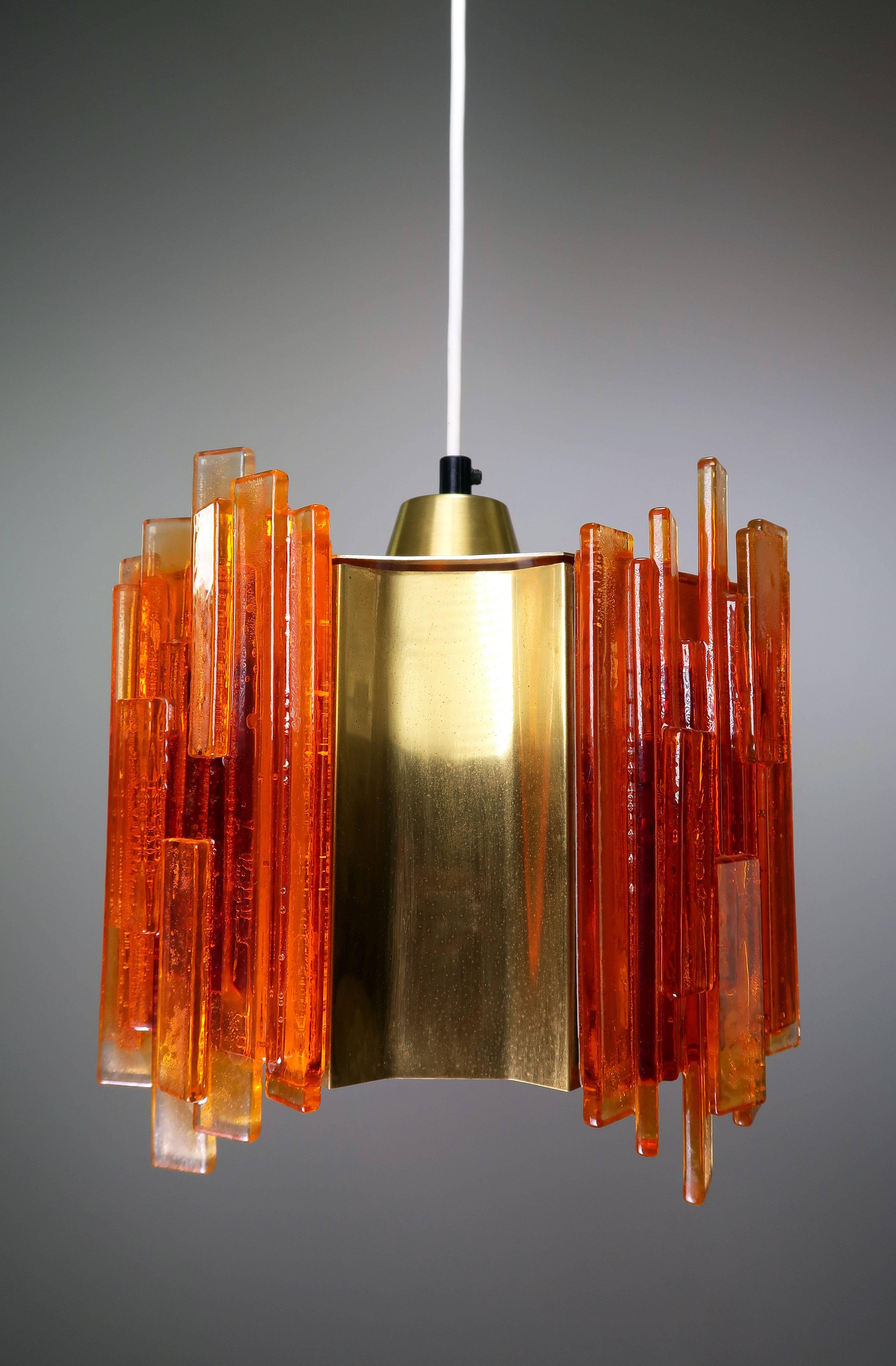 Danish Mid Century Scandinavian Modern Space Age octagon shaped pendant with four concave brass pieces intermixed with four orange acrylic pieces composed of many rectangular acrylic sticks arranged on top of each other to create a unique geometric