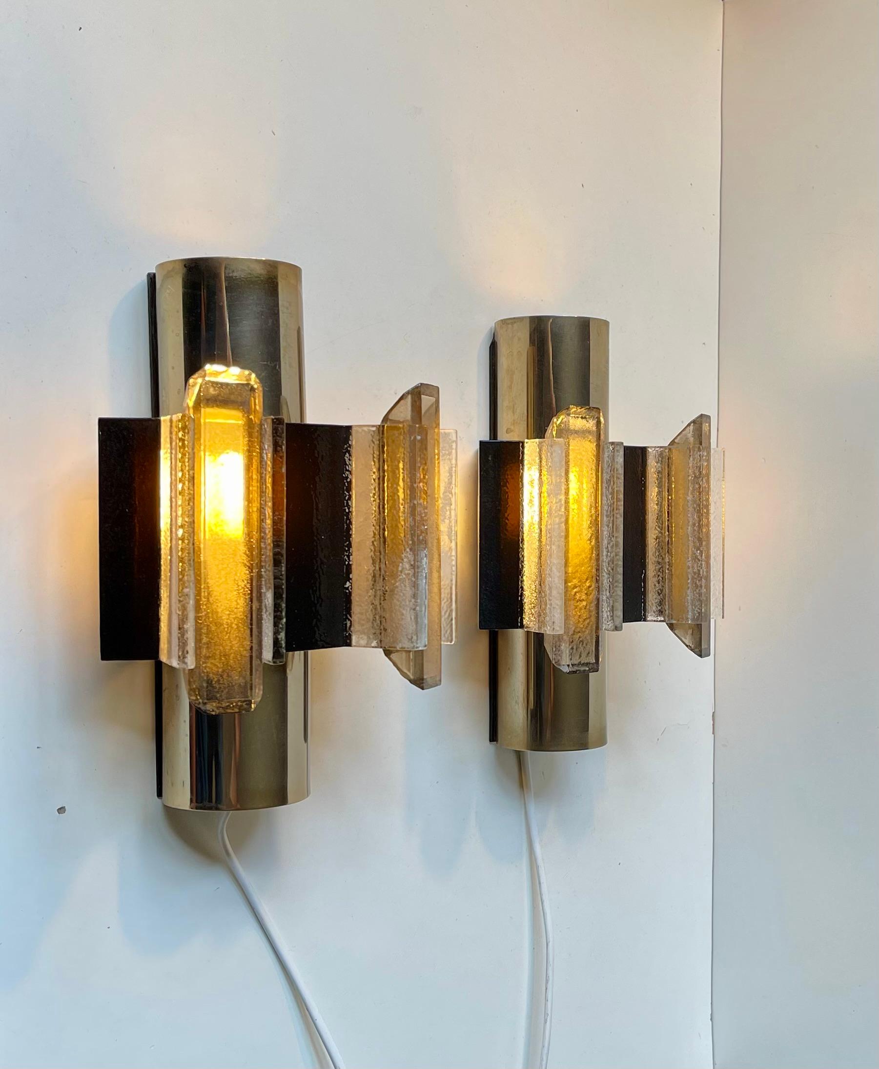 A rare pair of Danish Space Age or Brutalist wall lamps designed by Claus Bolby and manufactured by his own lighting company Cebo Industri in Silkeborg, Denmark in the late 60s to early 70s. The lamps are hand-made from layered strips of smooth