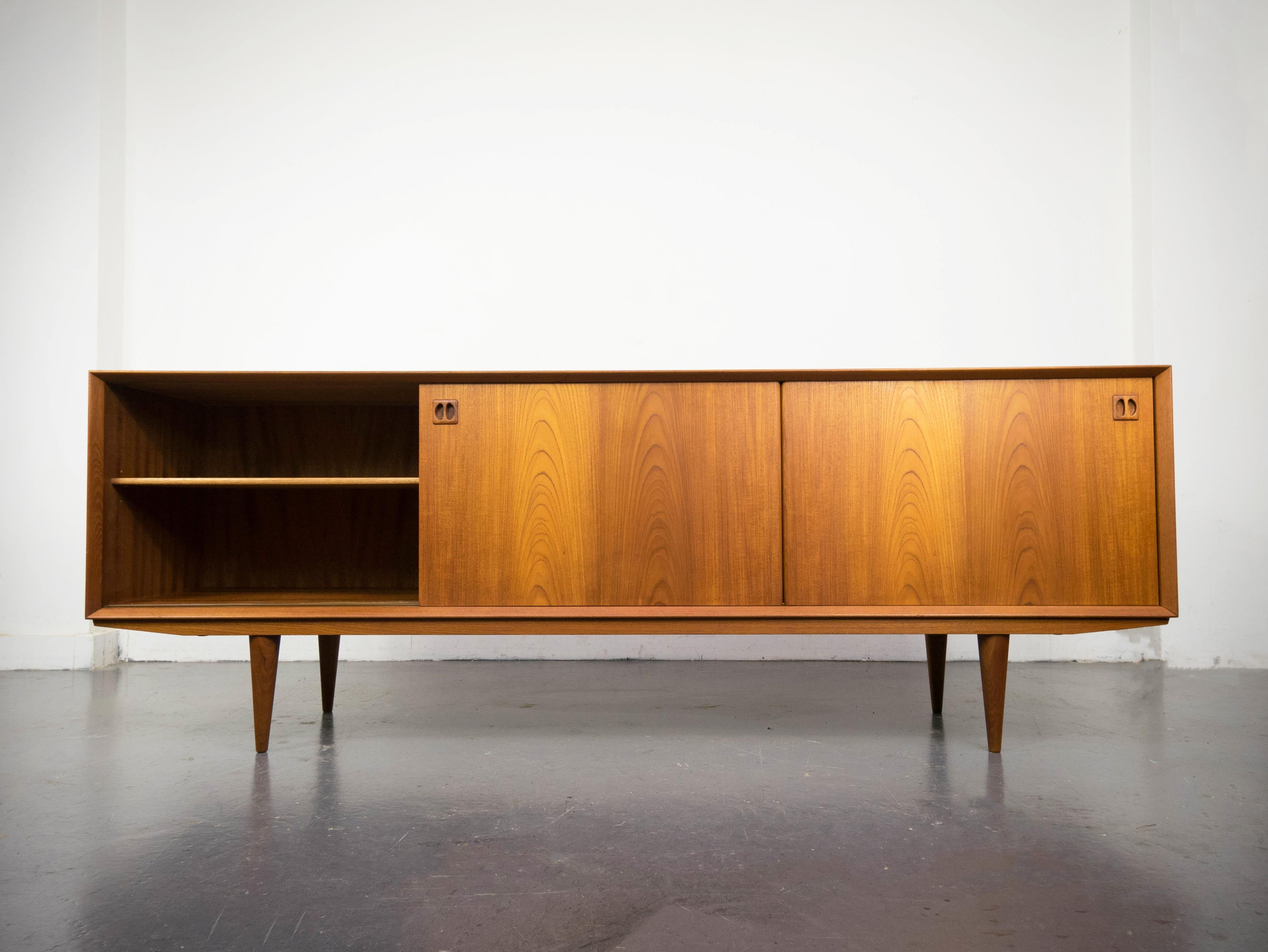A beautifully designed and crafted teak sideboard manufactured by Clausen and Son of Silkeborg, Denmark. Featuring a Minimalist modern design with superb build quality throughout. Luminous teak exterior, two large cupboards with adjustable shelf in