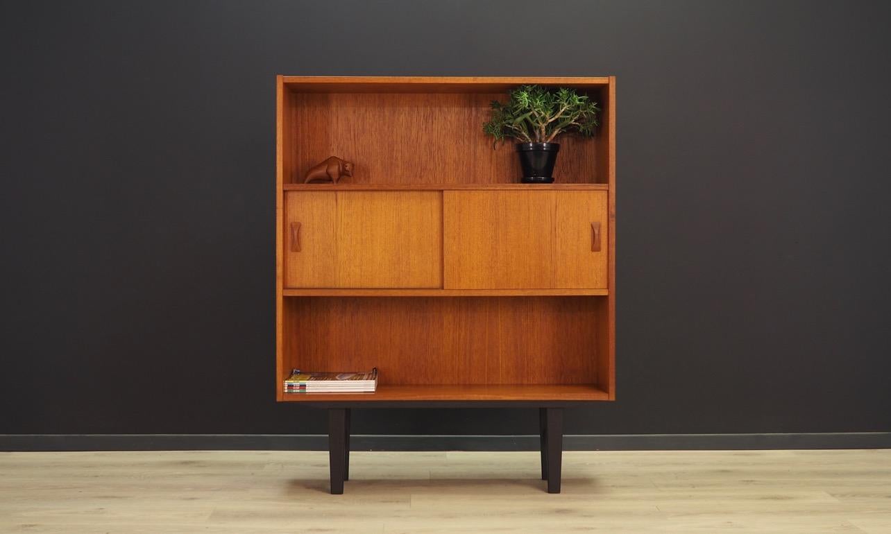 Bookcase from the 1960s-1970s. Manufactured by Clausen & Son. Bookcase finished with teak veneer. In the middle spacious interior behind sliding doors. Preserved in good condition (minor scratches and bruises), directly for use.

Dimensions: