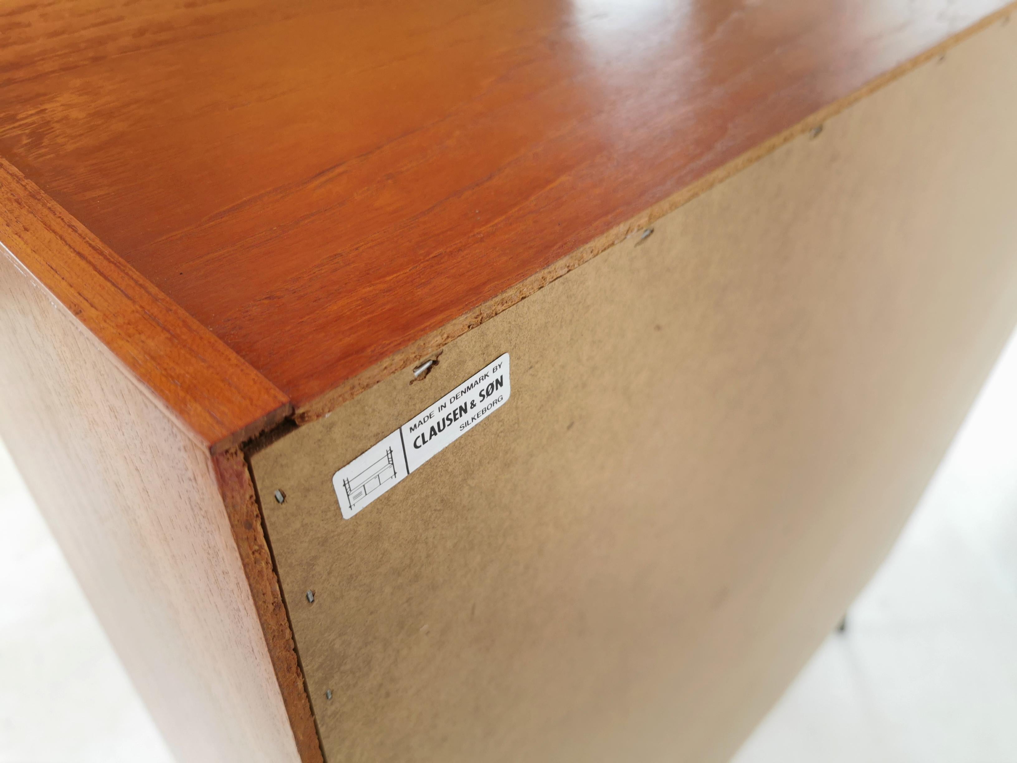 Clausen & Son teak bookcase
Bookcase raised on splayed ebonised legs. Top-quality, made in Denmark.
Made with teak, 1970s by Clausen & Son.
Featuring a fall front cabinet. Spaces for books and records.