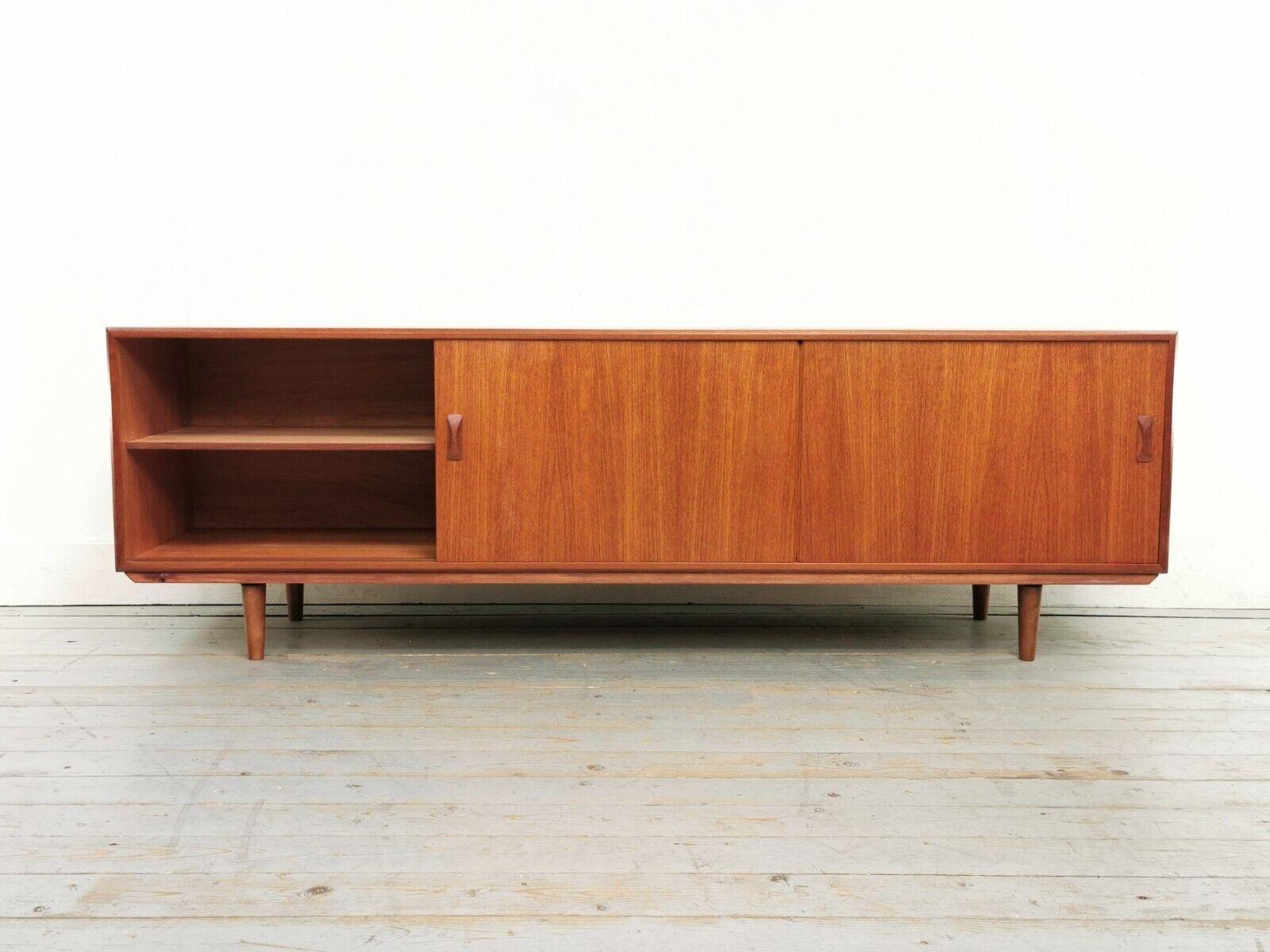 Clausen & Son teak sideboard raised on tapered legs. Two siding doors with four central drawers.

Top-quality, high-impact sitting at nearly 7 feet in width.

Overall this mid-century sideboard is in excellent vintage condition, we have pictured