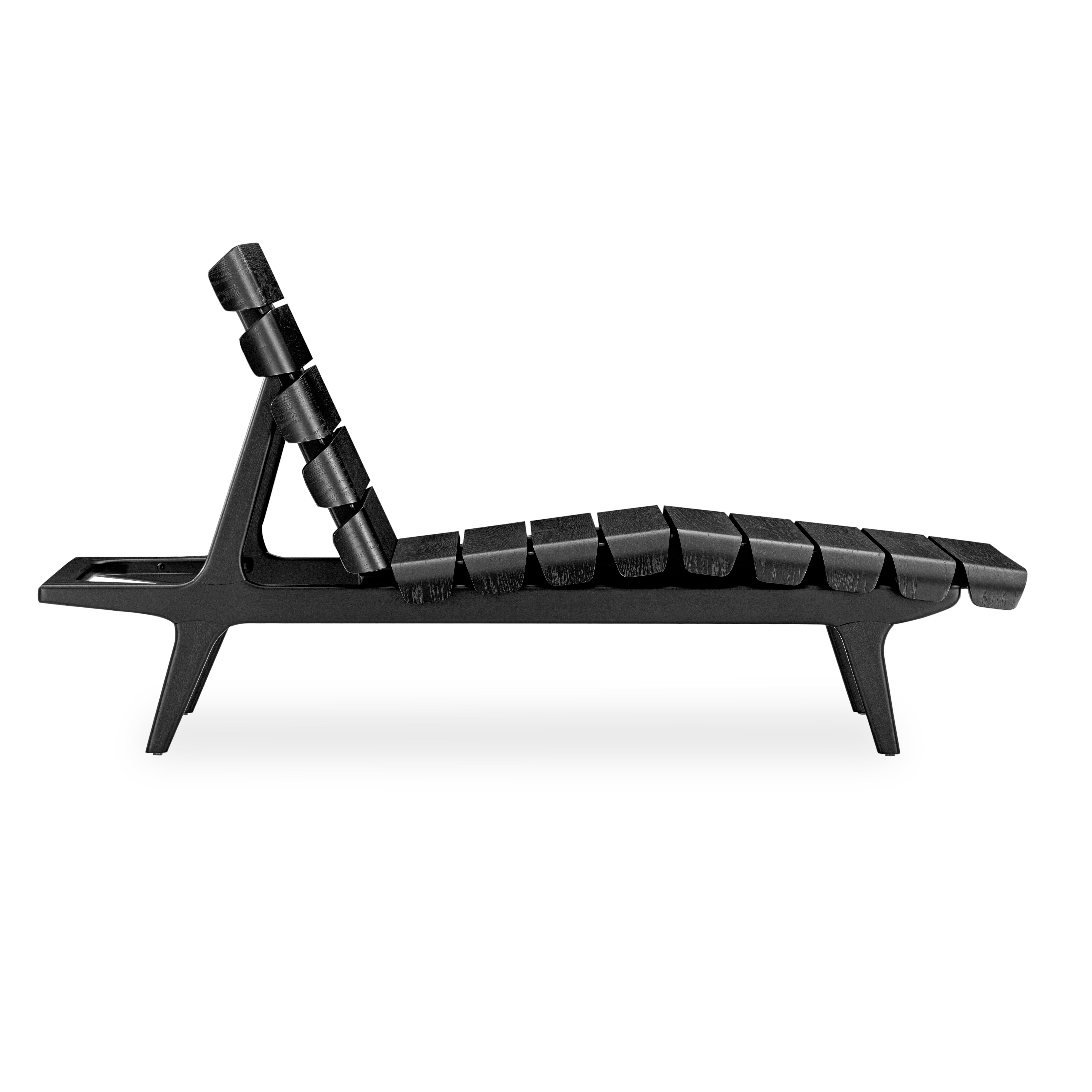 The Clave indoor chaise lounge in a monochromatic black wood Uultis finish, all made from wood, is the perfect addition for any contemporary, minimalist, or traditional design project. This chaise is the ideal chair to relax and lounge with its