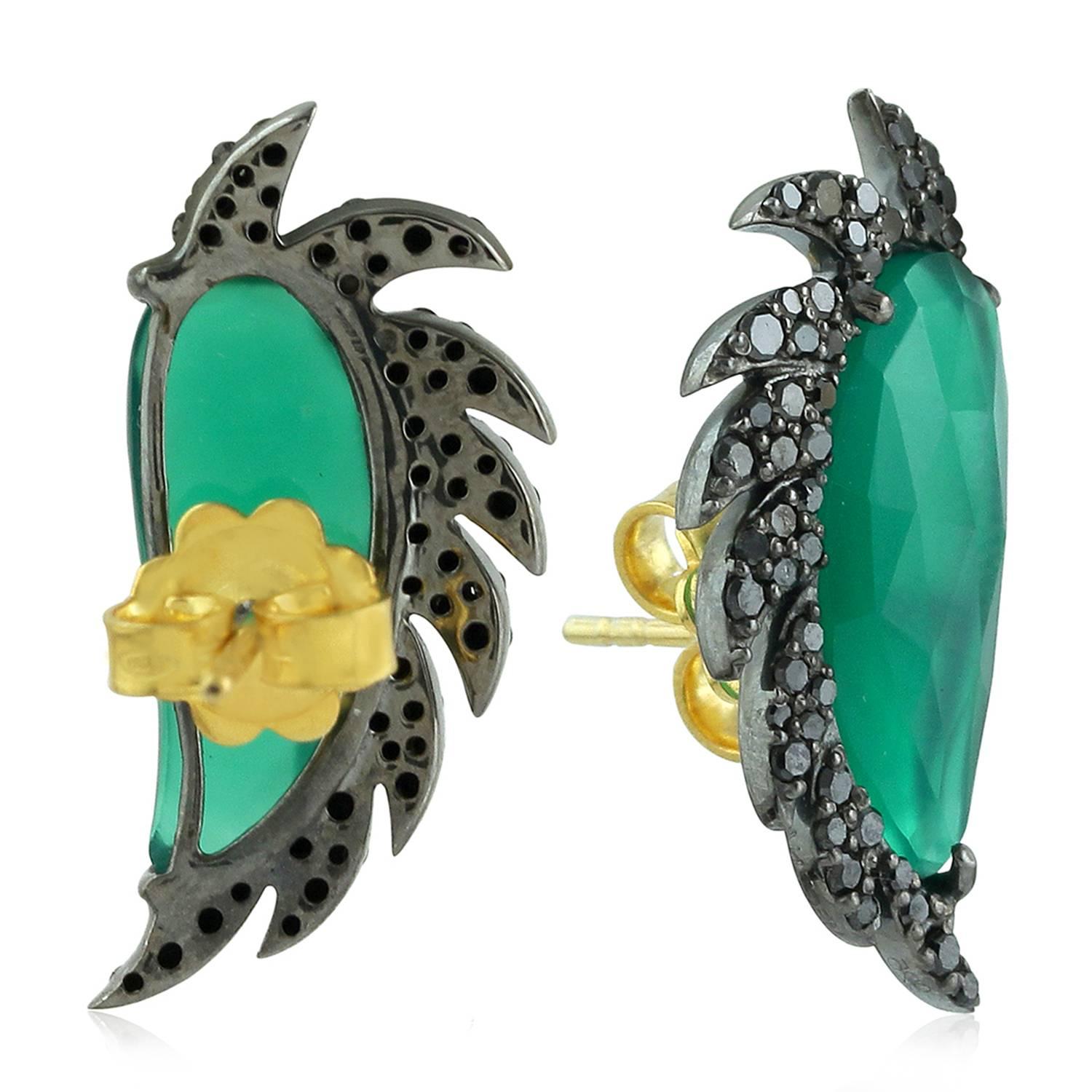 These distinctive stud earrings are modern twist to fine jewelry.. Handcrafted in 14K gold, sterling silver, green chalcedony and black diamonds. The iridescent 16.0-ct rose cut green chalcedony is surrounded by 0.67-ct signature diamond pave