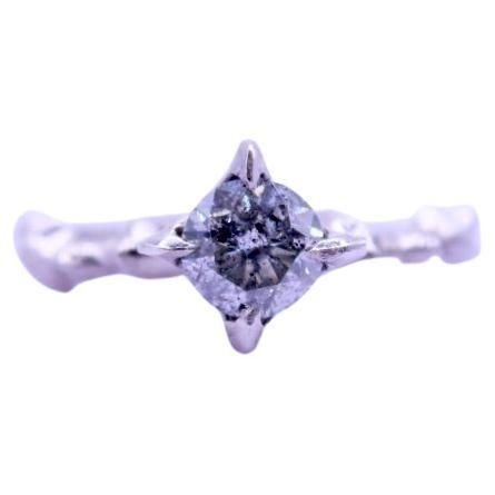 This 14 karat white gold ring is hand carved and set with a beautiful .83 carat salt and pepper diamond. The hand quality to this piece gives it a feeling of an ancient heirloom recently unearthed. The center stone glitters with flecks of black and
