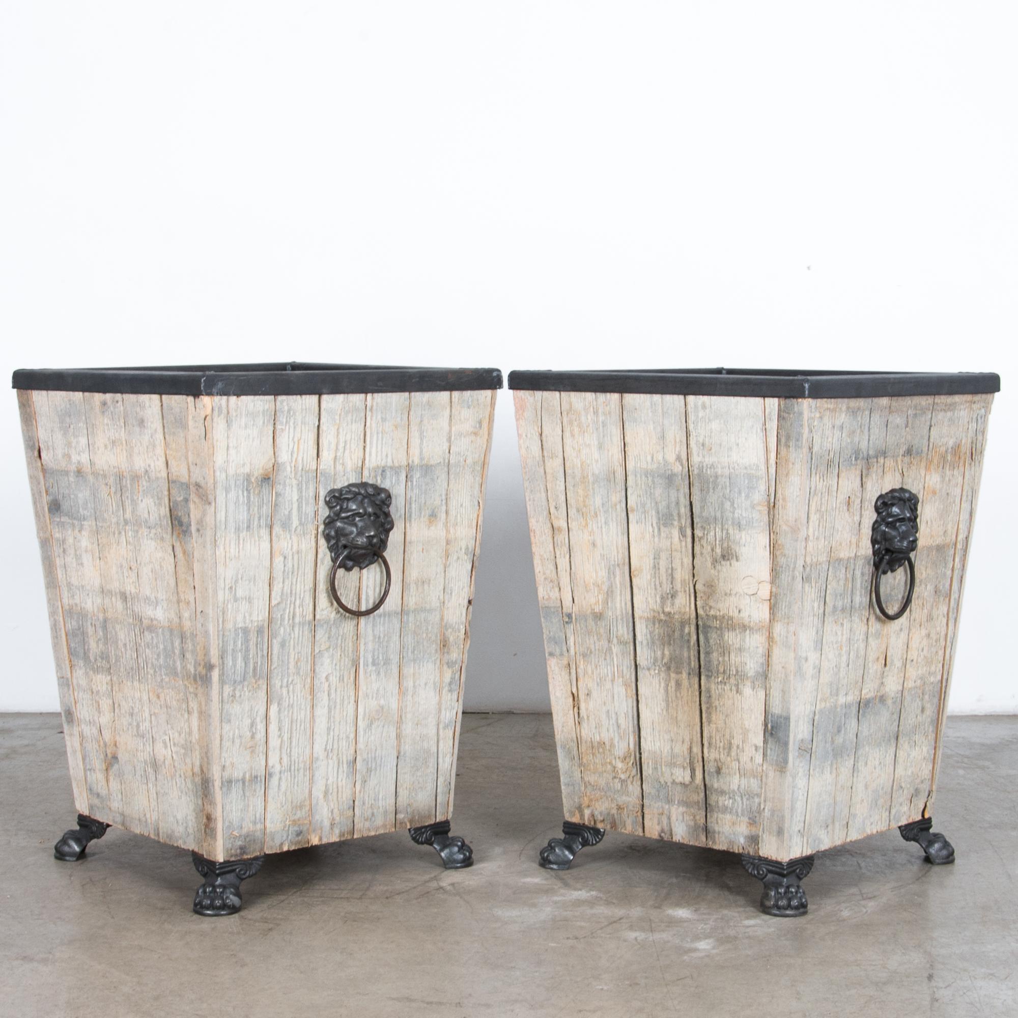 A pair of sturdy wooden garden planter produced in our atelier. The cool grey finish compliments textured softwood and polished cast iron. With a hint of traditional ornament, a cast iron elements elevate the piece with practical feet and handles.