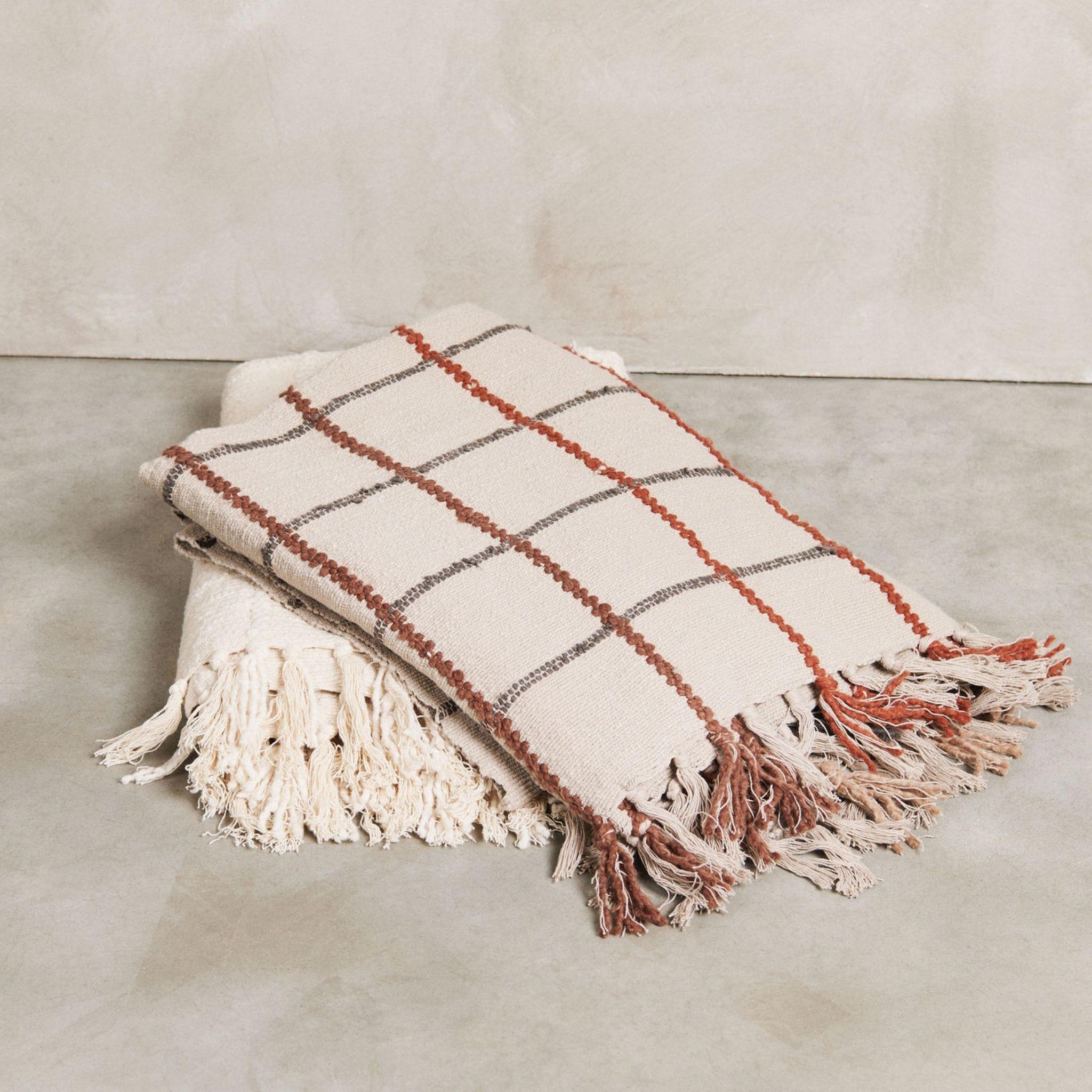 Le jeté Clay Handloom est tissé à la main par des tisserands en Inde. La conception du jeté d'argile  est composé d'un subtil motif de carreaux texturés formant un dégradé progressif de carreaux, tous créés à la main. . Les bords de ce jeté sont