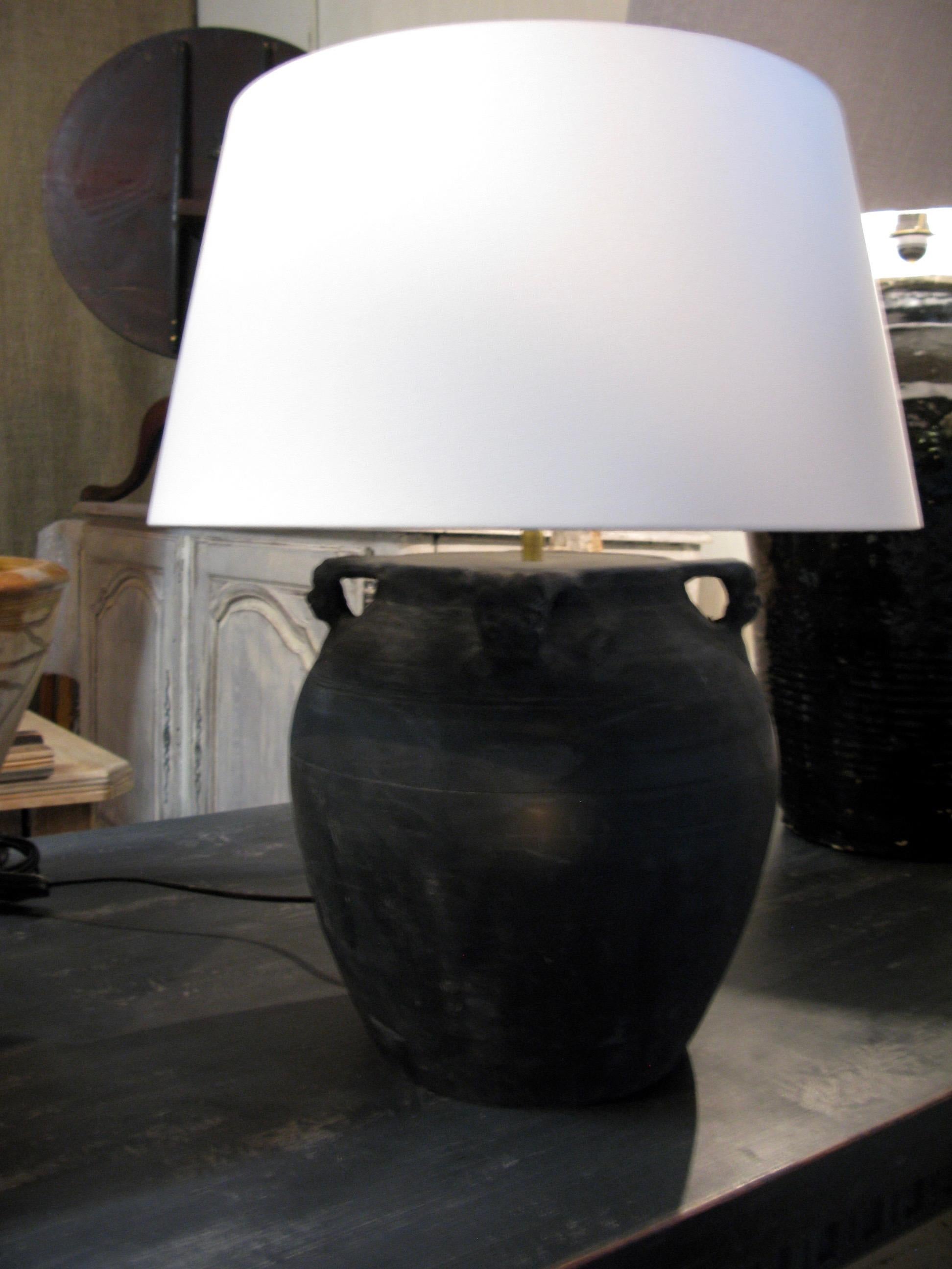 Spectacular lovely clay pot converted into a lamp with a white linen lampshade (taupe as well available)
Handles are Drake head ornaments

The pot has a dark-grey /black color

Height 62 cm incl lampshade

Eu fitting

2 available when