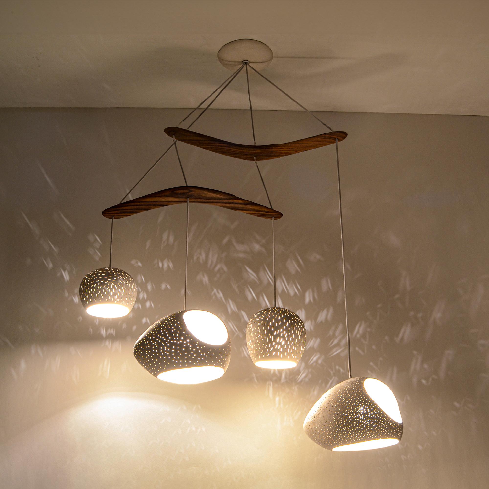 Ce lustre moderne est une déclaration d'éclairage sculpturale. Notre design tient compte de l'atmosphère créée par la lumière qui émane du luminaire autant que du design du luminaire lui-même. Lorsque la lumière est éteinte, quatre pendentifs en
