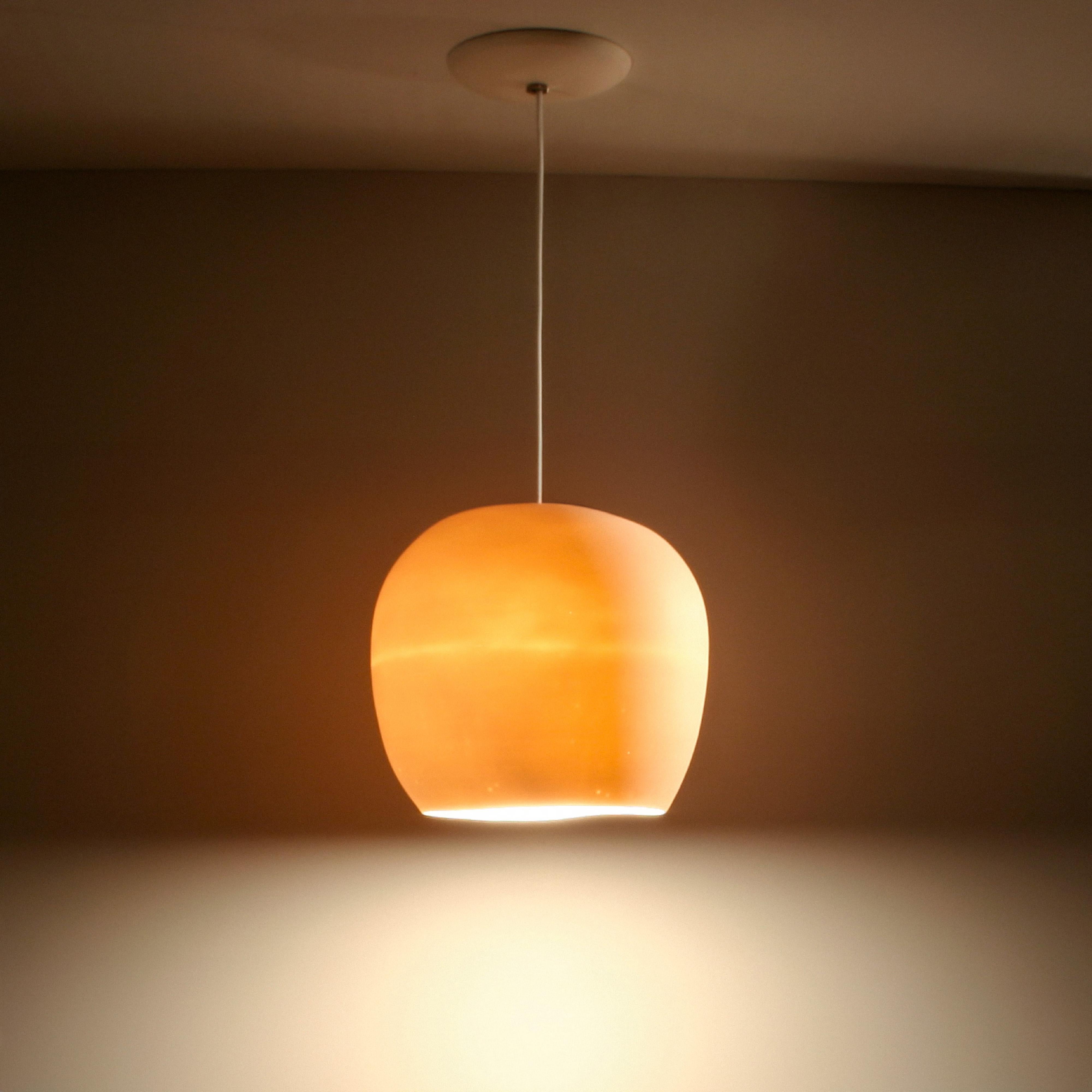 This egg shaped porcelain pendant lamp exudes understated elegance. When the light is off, the porcelain is matte warm white, but when the light is on, the pendant lamp glows an amber hue, creating a calming mood light. In addition to the soft, warm