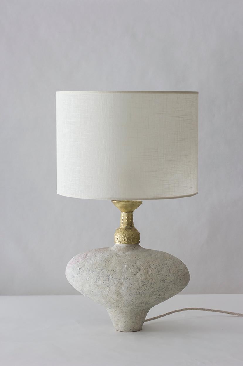 Clea lamp by Raquel Vidal and Pedro Paz
Measures: 35 x 59 cm
Materials: Shade: Linen
Neck: Brass
Body: Glaze stoneware
Cord: Linen

The pieces are hand built and brushed with glaze, resulting in slight variations of form and glazed surface