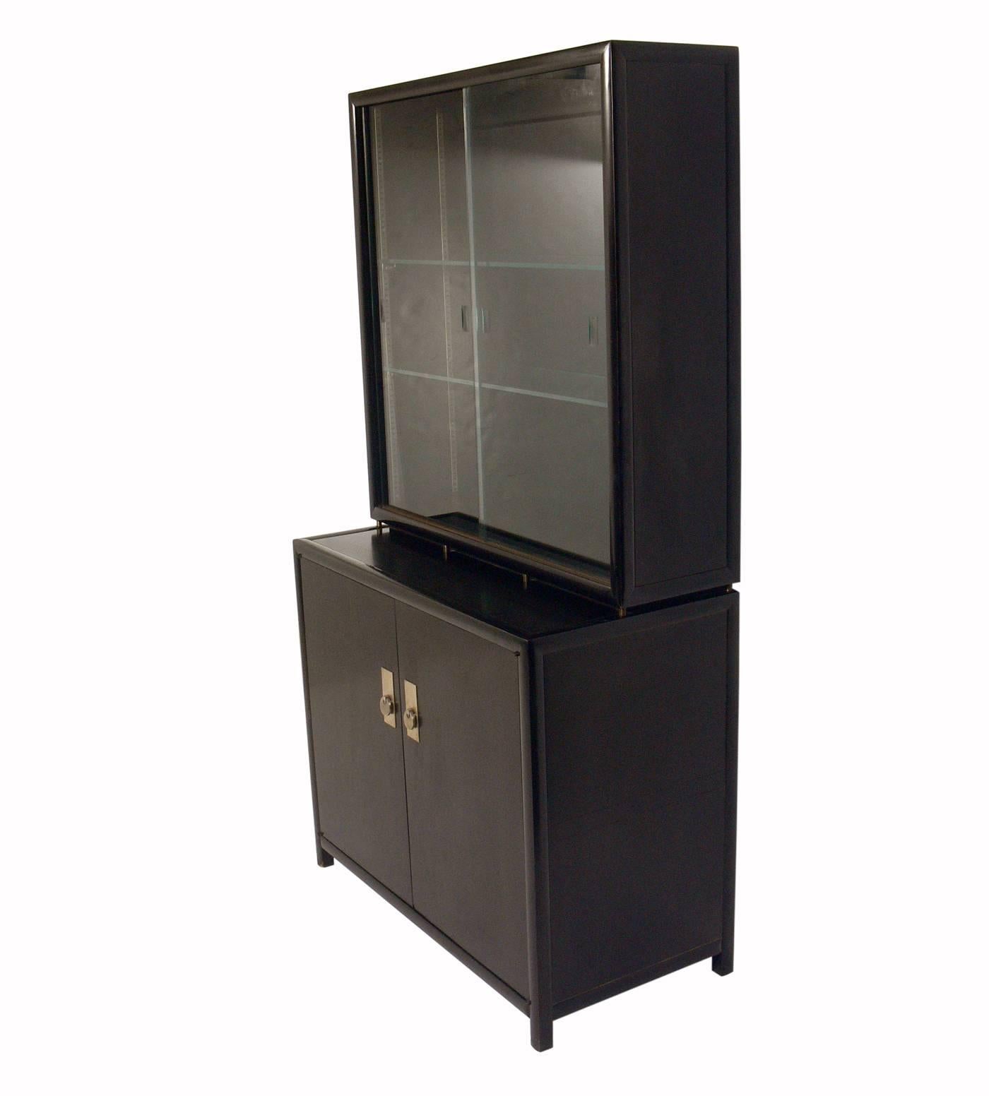 Clean lined bar cabinet or vitrine, designed by Michael Taylor for Baker, American, circa 1960s. Subtle Asian influenced design. This piece is a versatile size and can be used as a bar cabinet, vitrine, or bookshelf in a living area, or as a dresser