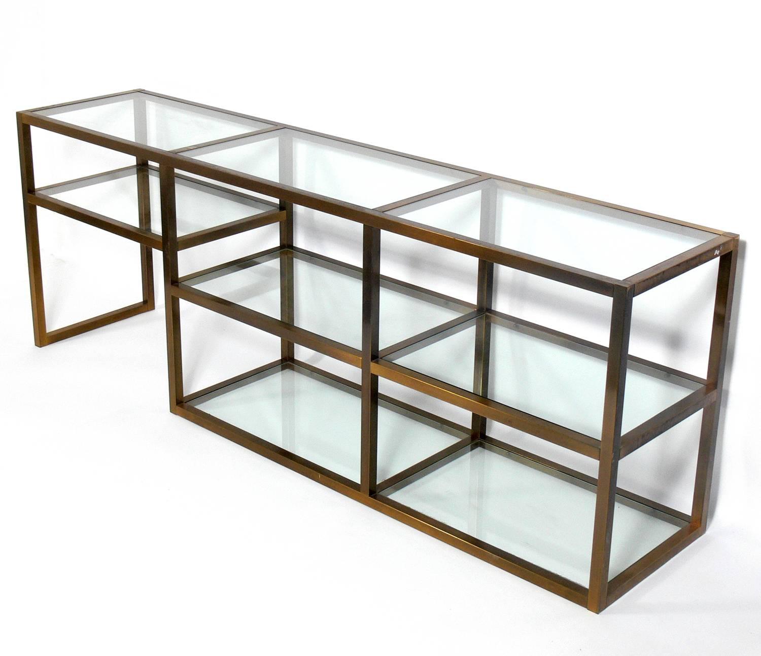 Clean lined brass and glass bookshelf or vitrine, American, circa 1960s. This piece is a versatile size and can be used as a bookshelf, vitrine, display case, bar, or media cabinet. Retains warm original patina to brass and brass plated metal.