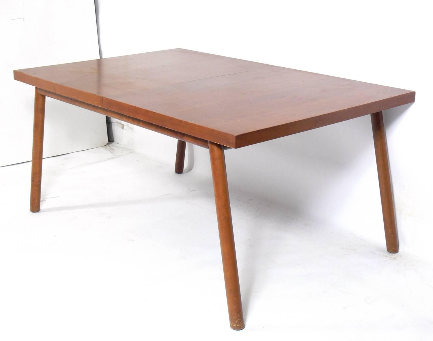 Clean lined dining table, designed by T.H. Robsjohn-Gibbings for Widdicomb, American, circa 1950s. It goes from a compact rectangle that measures 62