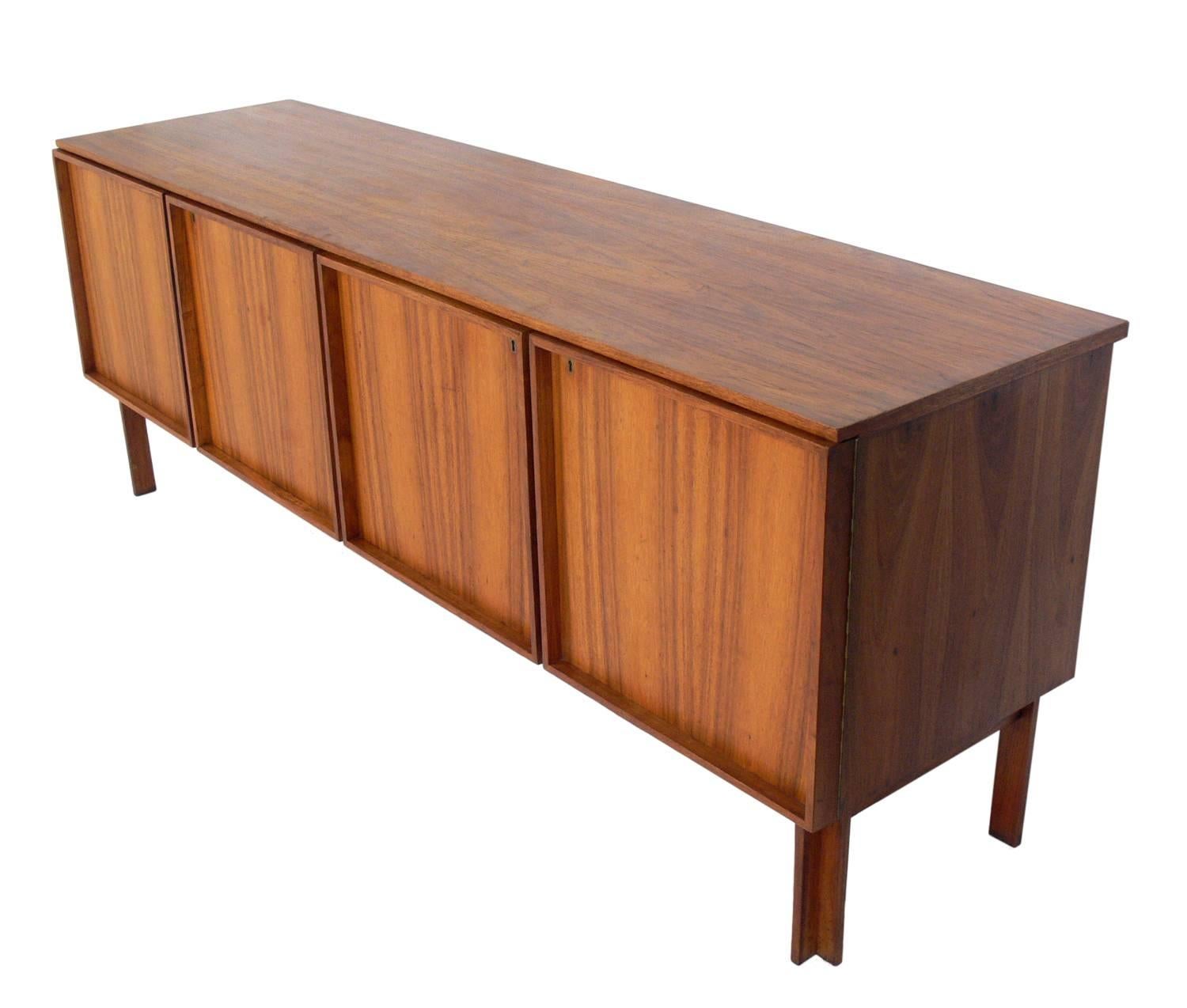 Clean lined midcentury credenza, designed by John Tabraham for Kallenbach, South African, circa 1960s. Retains wonderful original patina. This piece is a versatile size and can be used as a credenza, sideboard, media cabinet, or bar. It offers a