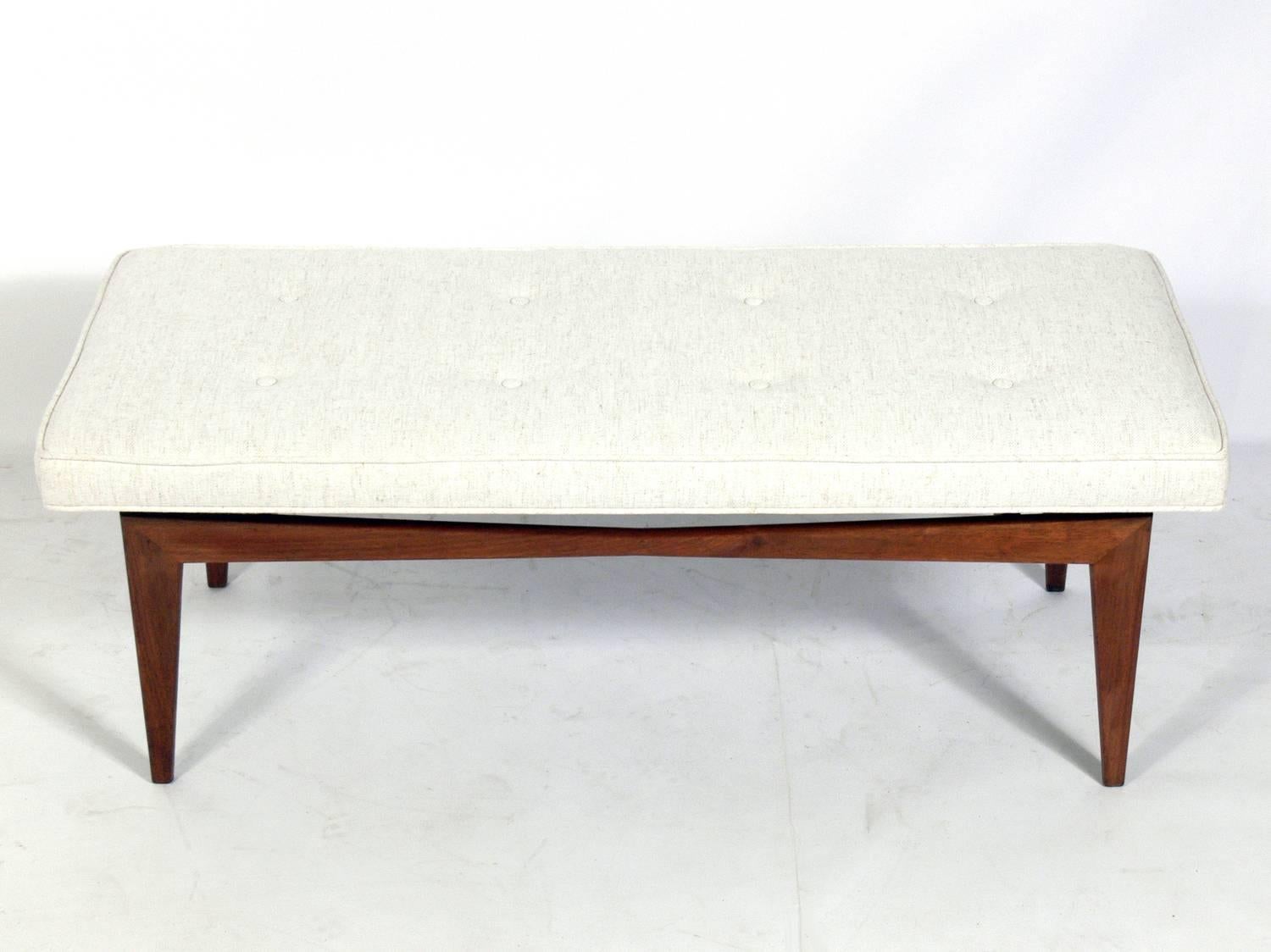 Clean lined midcentury walnut bench, in the manner of Jens Risom, American, circa 1950s. The simple architectural design appears to float the seat over the base. It is a versatile size and would be perfect at the end of the bed, or as occasional