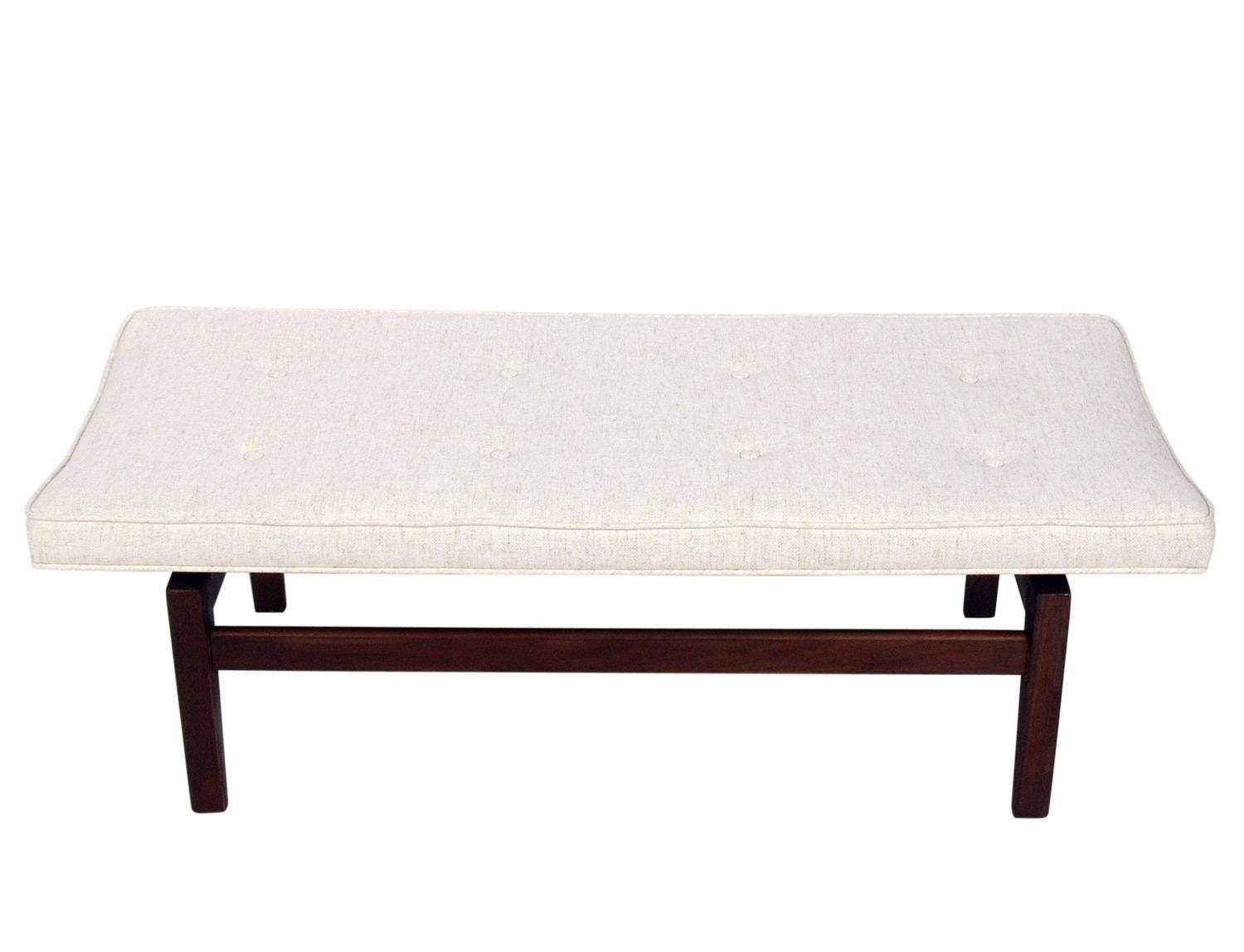 Clean lined walnut bench, designed by Jens Risom, American, circa 1950s. The simple architectural design appears to float the seat over the base. It is a versatile size and would be perfect at the end of the bed, or as occasional seating in a living