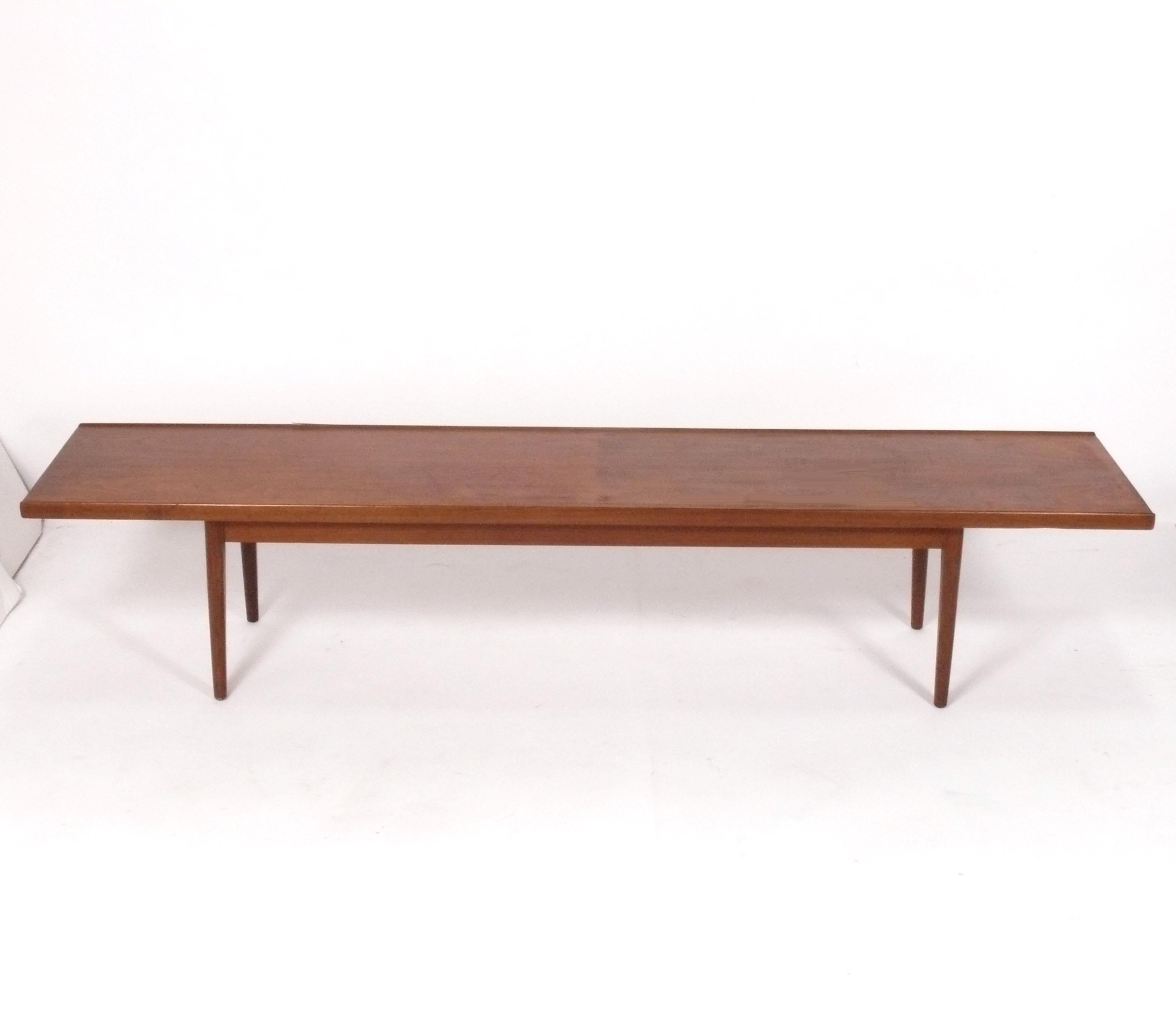 Clean lined midcentury walnut bench, designed by Kipp Stewart for Drexel, American, circa 1950s. It is a versatile size and can be used as a coffee table or bench. Beautiful graining to the walnut top. 
