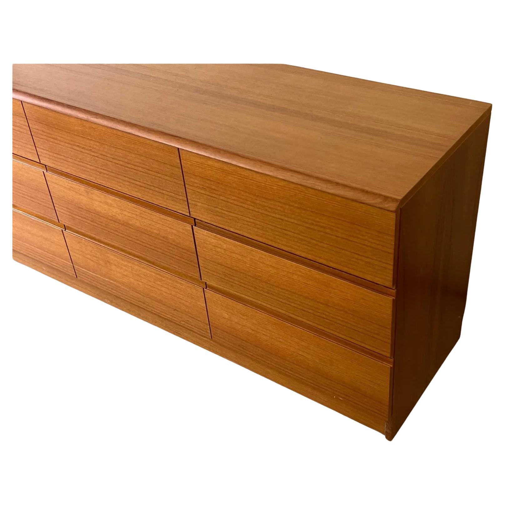 Mid century Danish modern Teak 9 drawer dresser. Clean simple Danish modern dresser with 9 drawers clean inside and out. Has carved lower handle pulls under drawer face. Really beautiful medium brown teak wood with very nice grain. Made in Denmark.