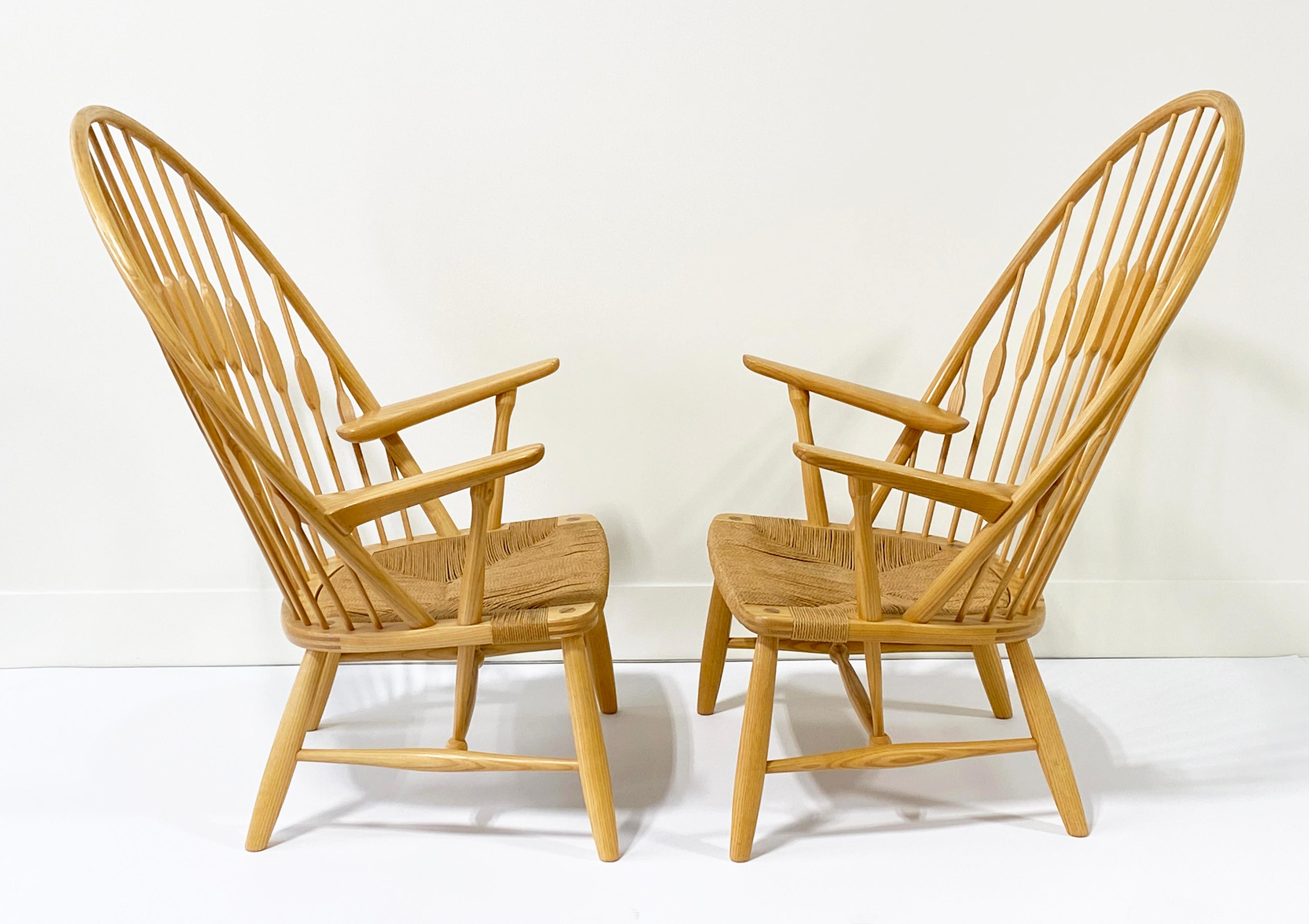Hier ist ein sehr schönes Paar Pfauenstühle, entworfen von Hans Wegner für Johannes Hansen aus Dänemark. Diese Stühle wurden aus dem Nachlass eines Designers erworben, in dem alles tadellos gepflegt wurde, und diese Stühle sind keine Ausnahme. Sie