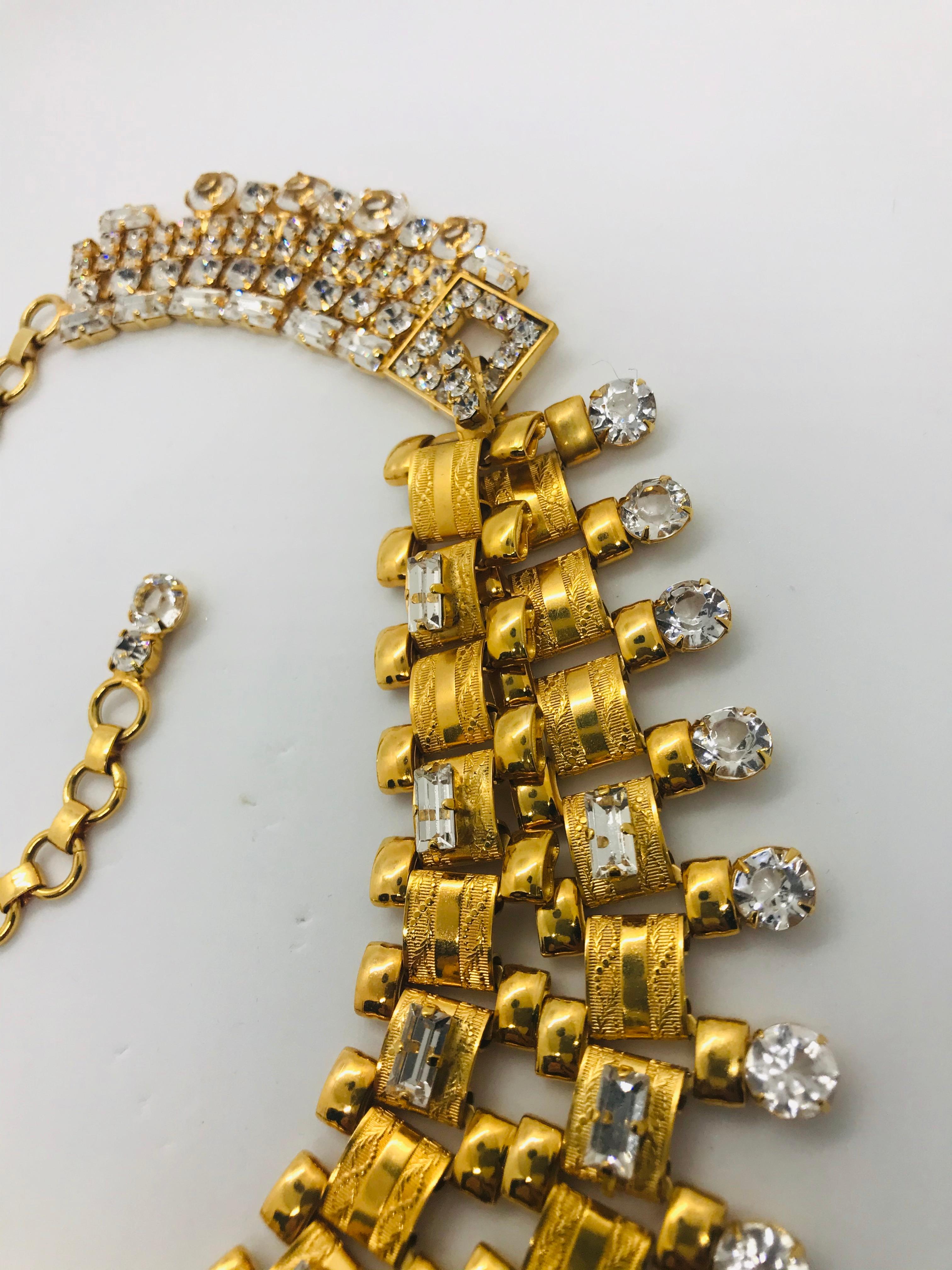 Our glamorous clear Austrian crystal Art Deco Machine Age swag front necklace invokes the glamour of 1930s Hollywood!  This necklace features a double swag front of embossed Art Deco metal link chain scattered with 1960s clear Austrian crystals. 