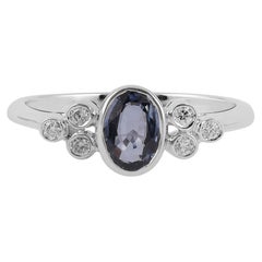 Bague en or 18 carats avec saphir bleu clair entouré de diamants ronds taille brillant