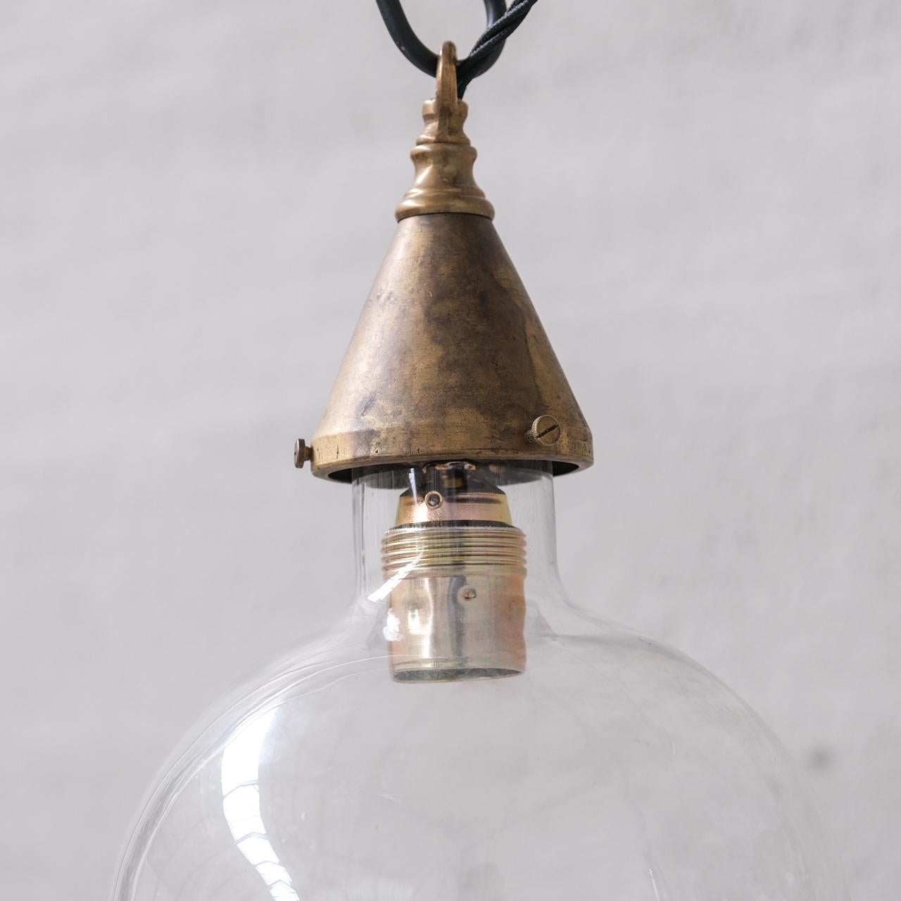 A clear glass bulb like shade pendant light, good quality brass gallery.

France, c1960s.

Single available.

No rose was retained or chain, however they are easy to source online.

Good vintage condtion, re-wired and PAT tested.

Location: Belgium
