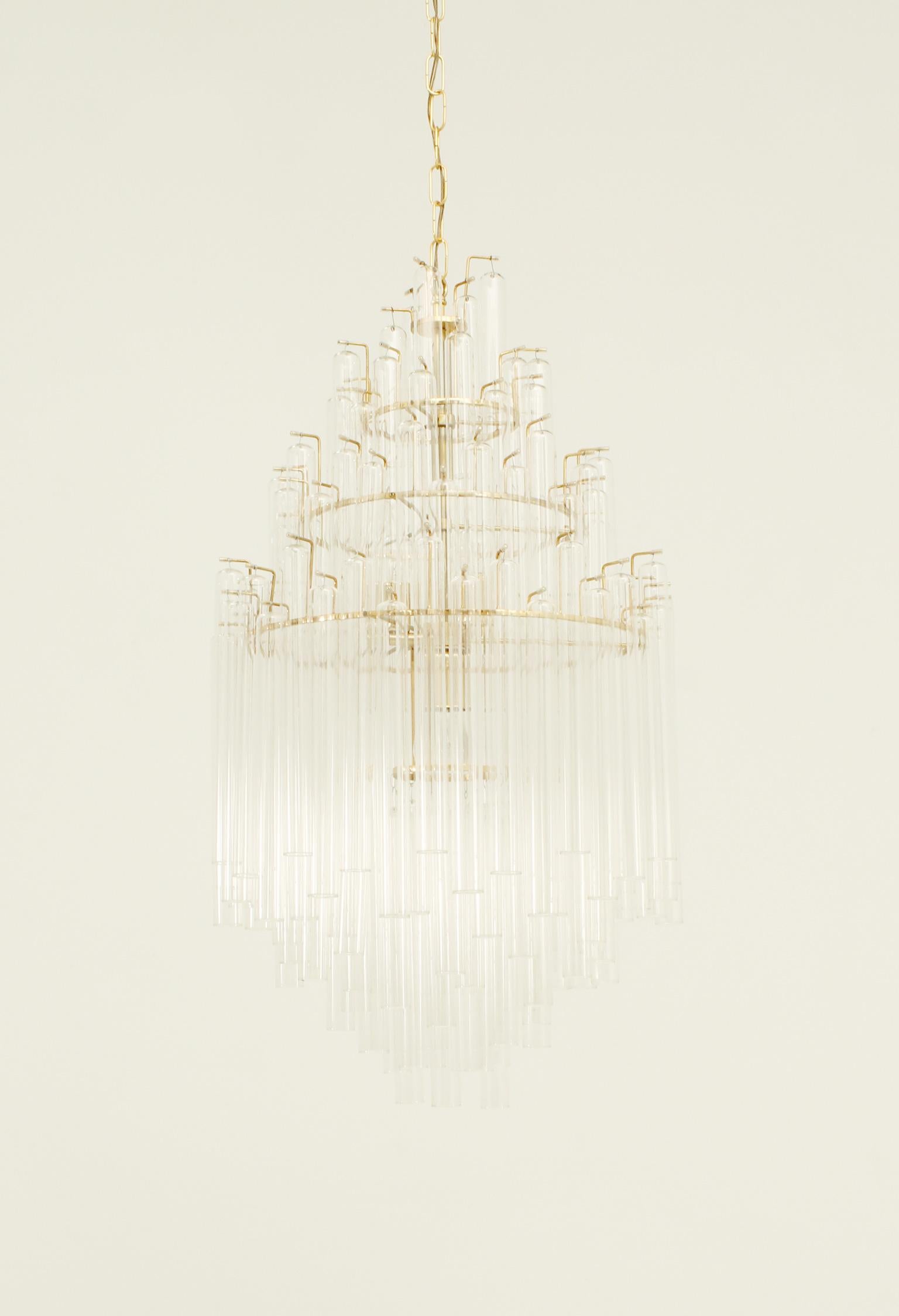 Important chandelier from 1970's, Italy. Formed of multiple clear glass tubes with different sizes and brass structure with four light bulbs.