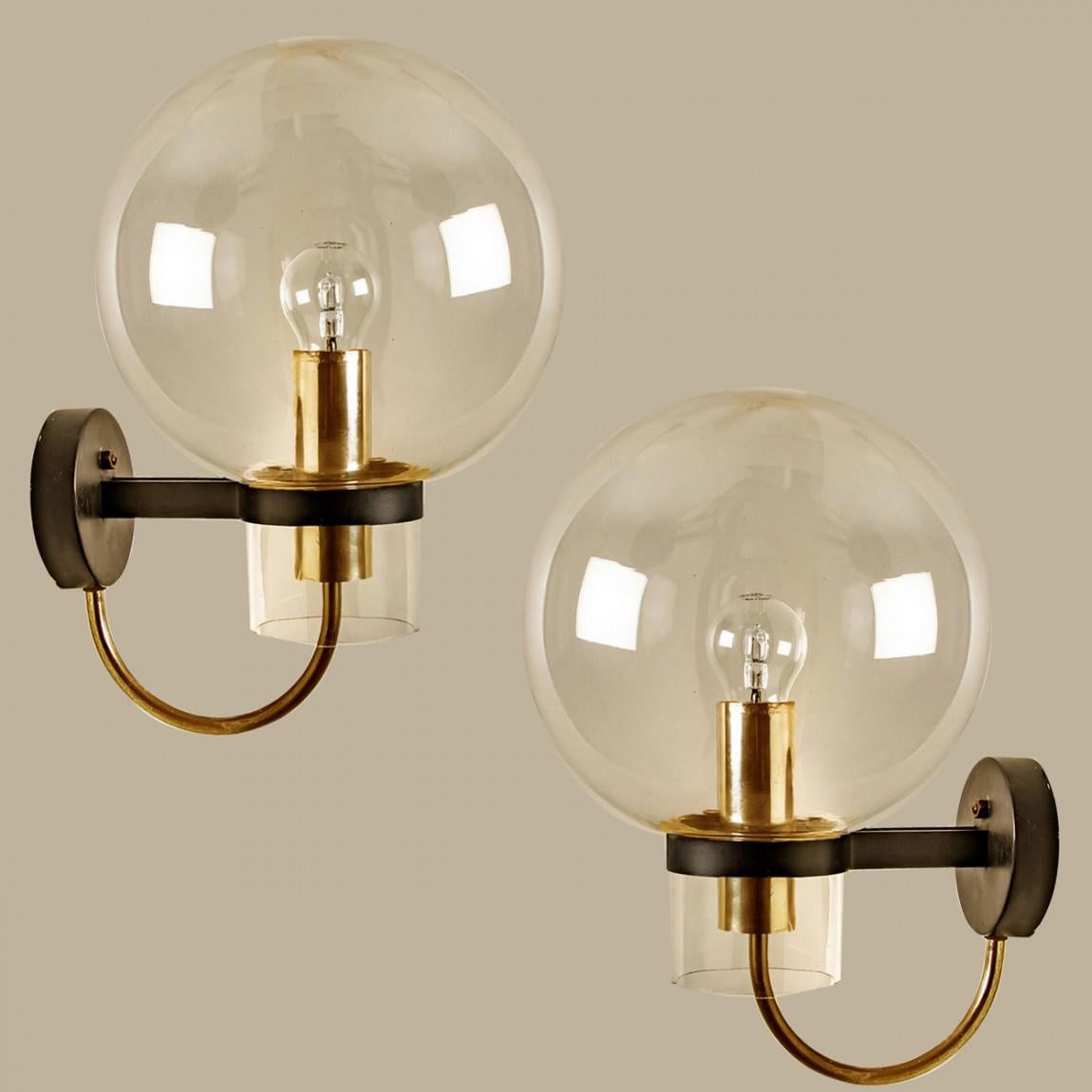 Large quantity of beautiful hand blown clear glass wall lights with brass details. Designed and manufactured by Glashütte Limburg, Germany around 1975.

Beautiful craftsmanship. These midcentury vintage lights feature handmade, elaborate clear