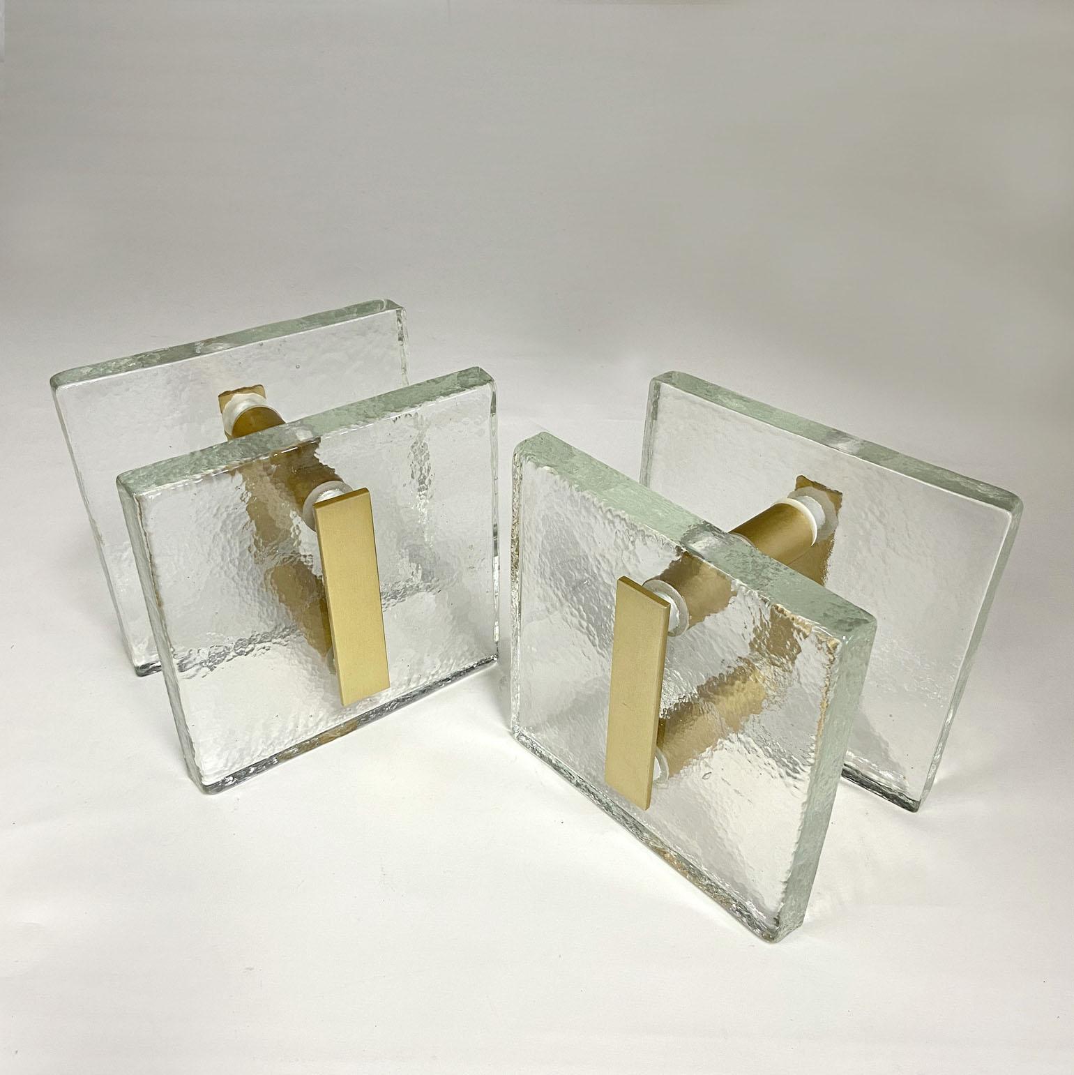 Ein Paar Doppeltürgriffe, drückend und ziehend, quadratisches strukturiertes klares Gussglas mit mattgold eloxiertem Aluminium. Sie sind für Glas- oder Holztüren konzipiert, eignen sich aber für alle Arten von Türen. Die Glasplatten werden gegossen,