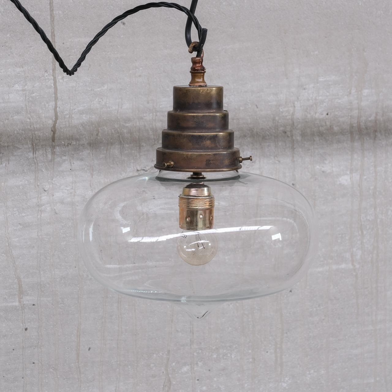 A clear tear drop pendant light.

France, circa 1950s.

Stepped brass gallery.

Good condition.

Re-wired and PAT tested.

No original chain or rose was retained but these can be sourced easily online.

Location: Belgium